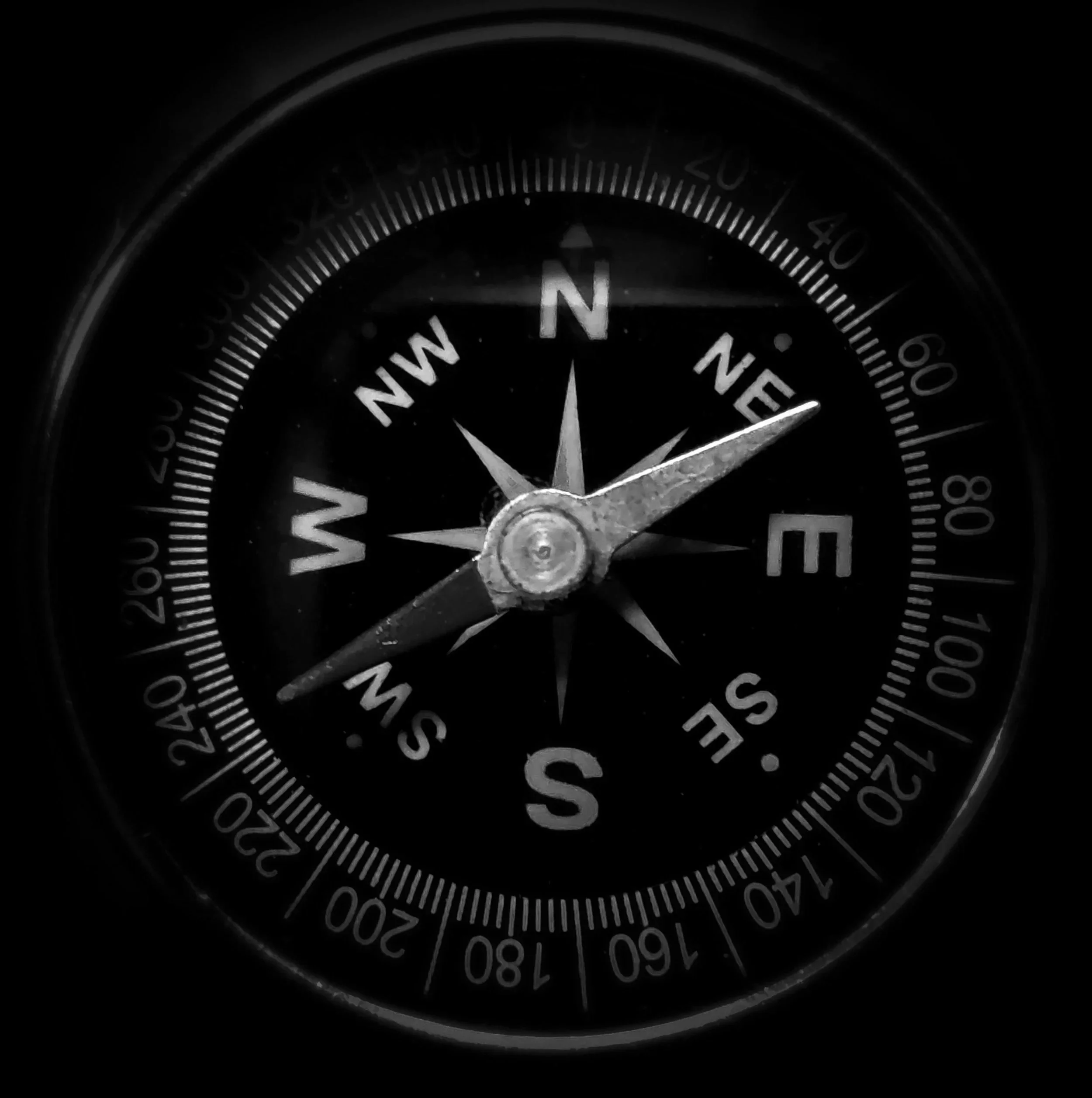 A close-up of a compass showing north-northeast.