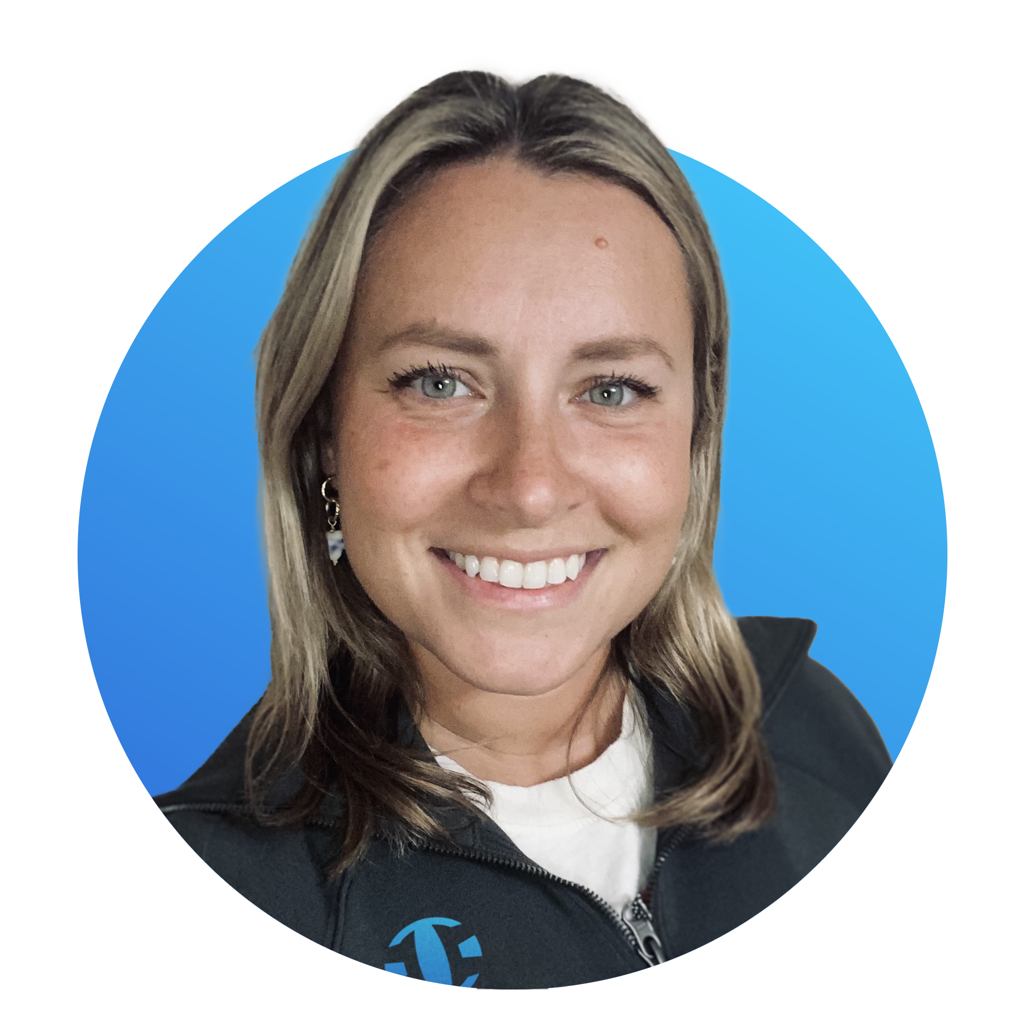 A woman with blonde hair smiling, wearing a black jacket over a white shirt, with a blue background.