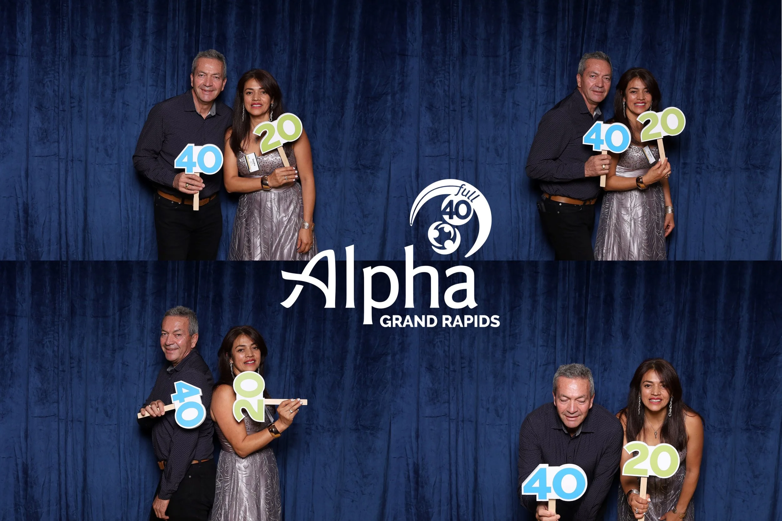 Two men and two women at a celebratory event holding signs that read 40, 20, and 40, with a logo and text that says 'Alpha Grand Rapids' and 'Full 40' against a blue curtain background.