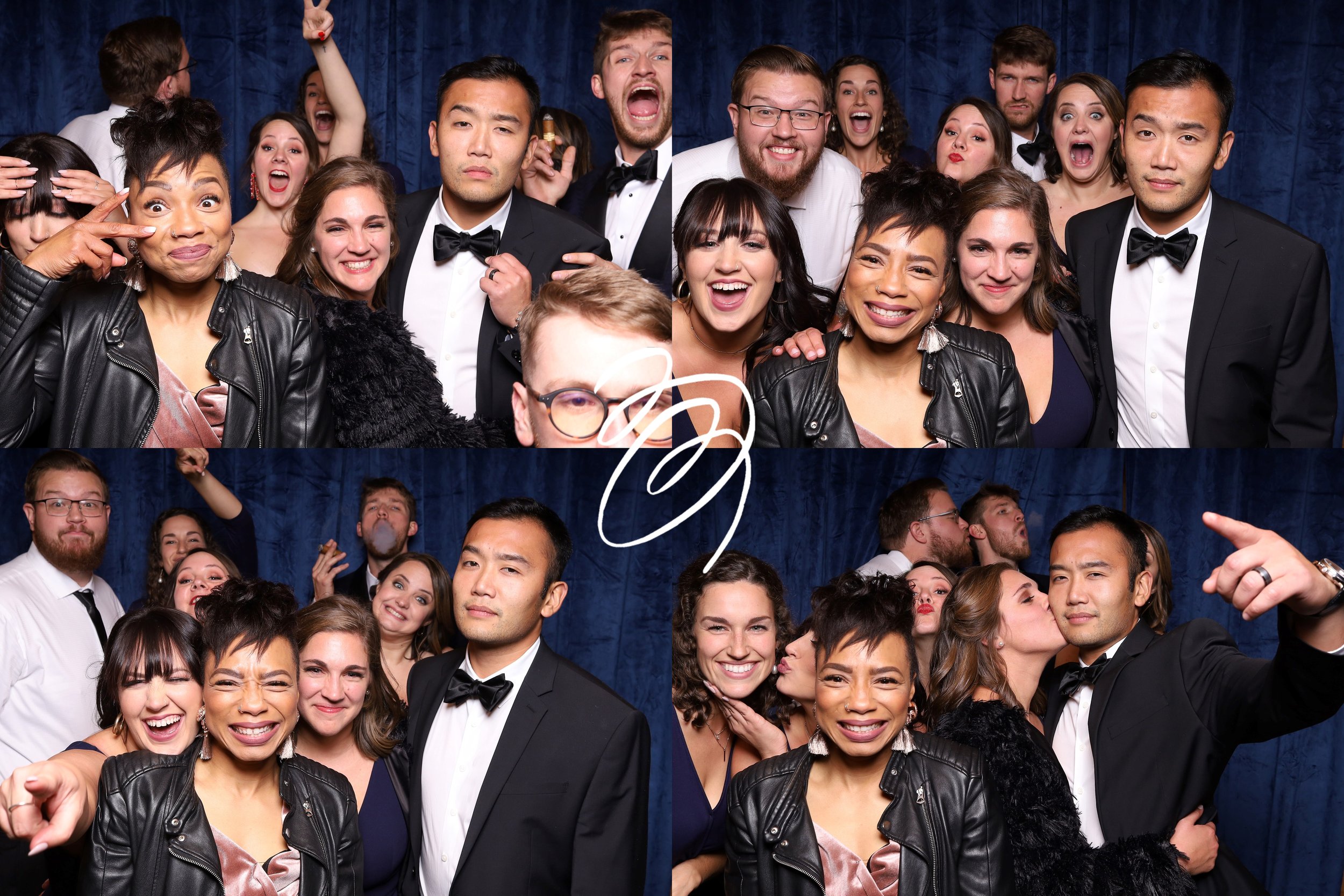 A group of people dressed in formal attire posing together in a photo booth with a dark blue curtain background. Some are smiling, making funny faces, kissing, or taking selfies.
