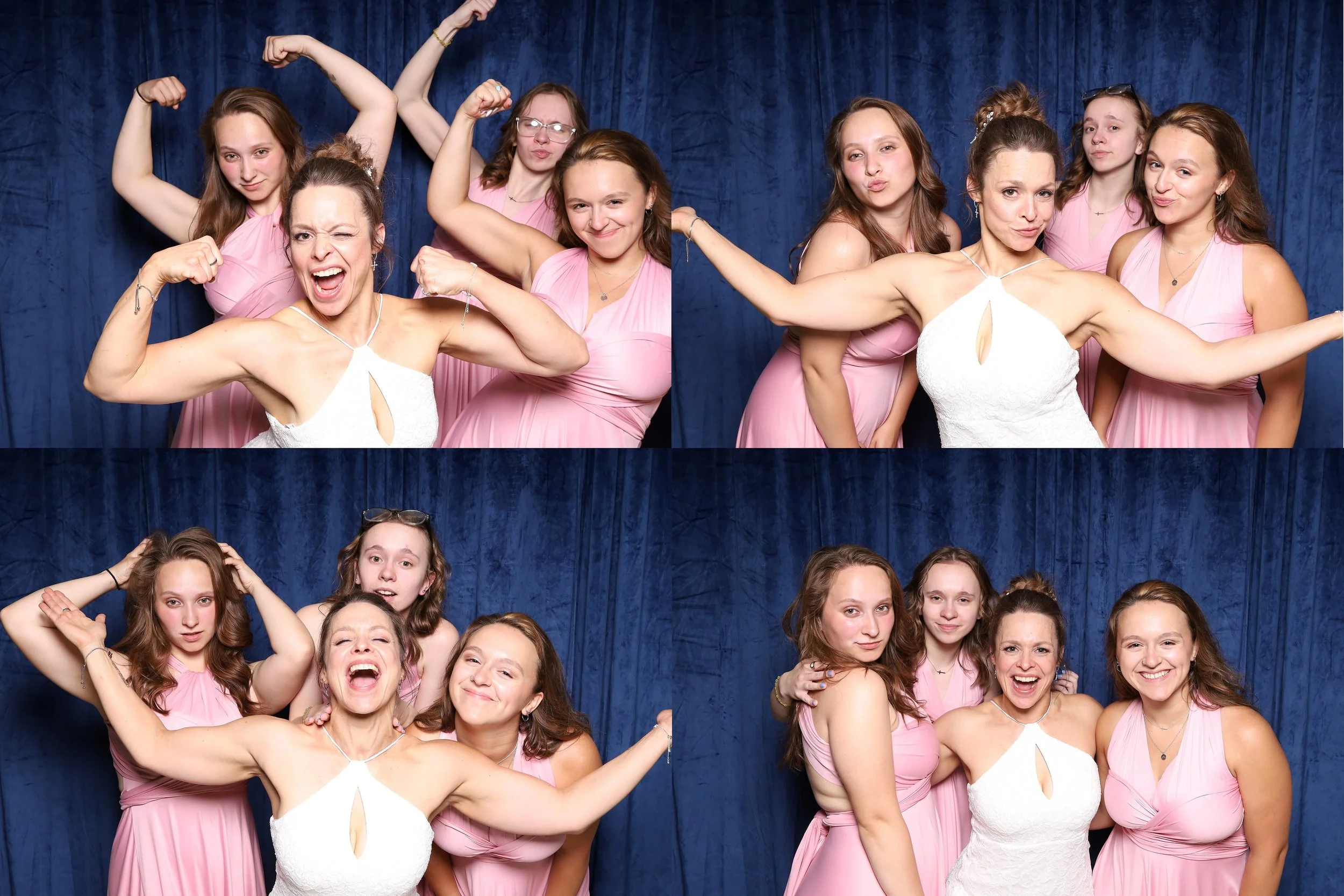 A group of women and teenage girls posing together against a blue curtain backdrop, with some flexing muscles, making playful faces, and hugging, all wearing matching pink dresses.