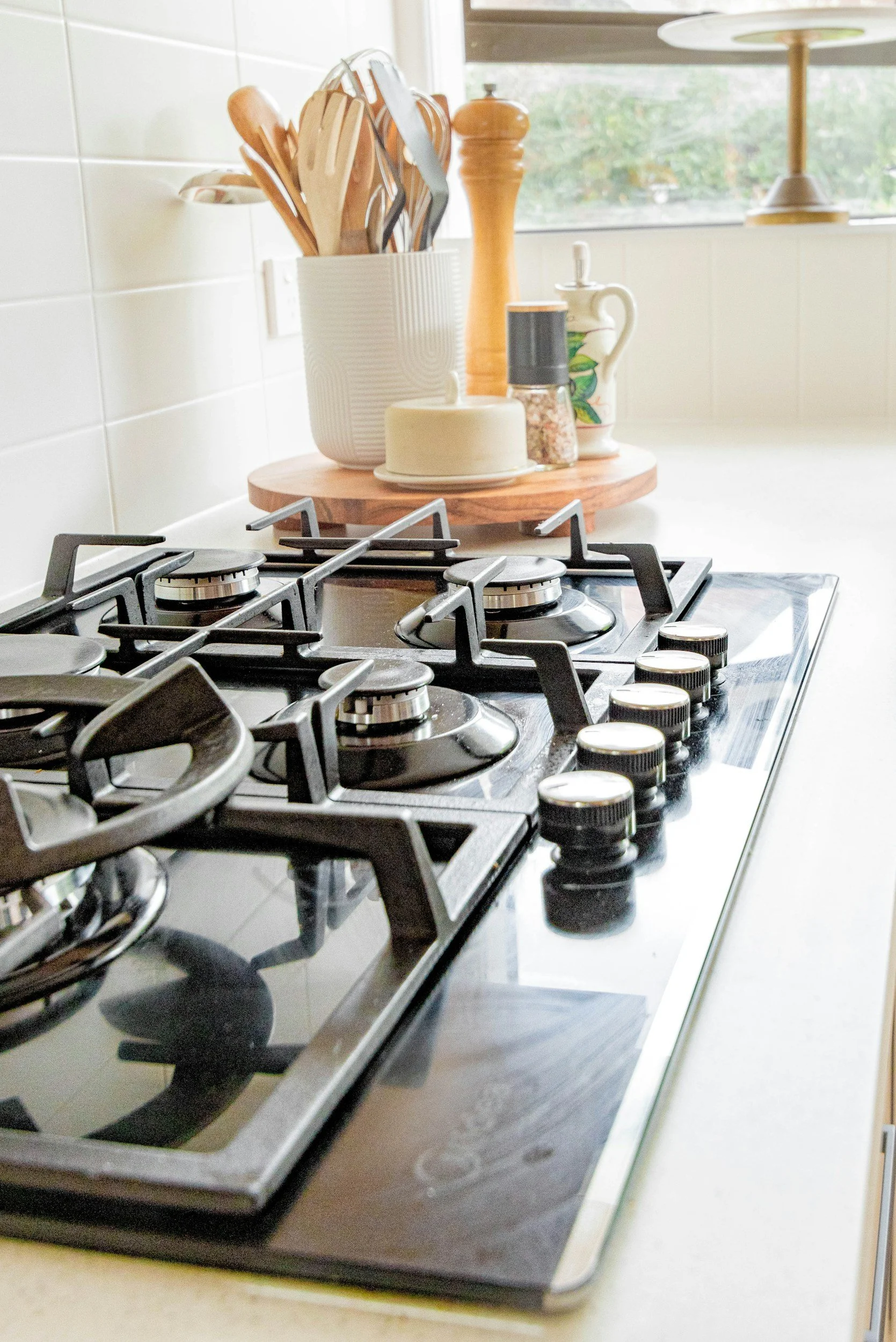 Estufa de cocina de gas con utensilios de cocina y especias en la encimera.