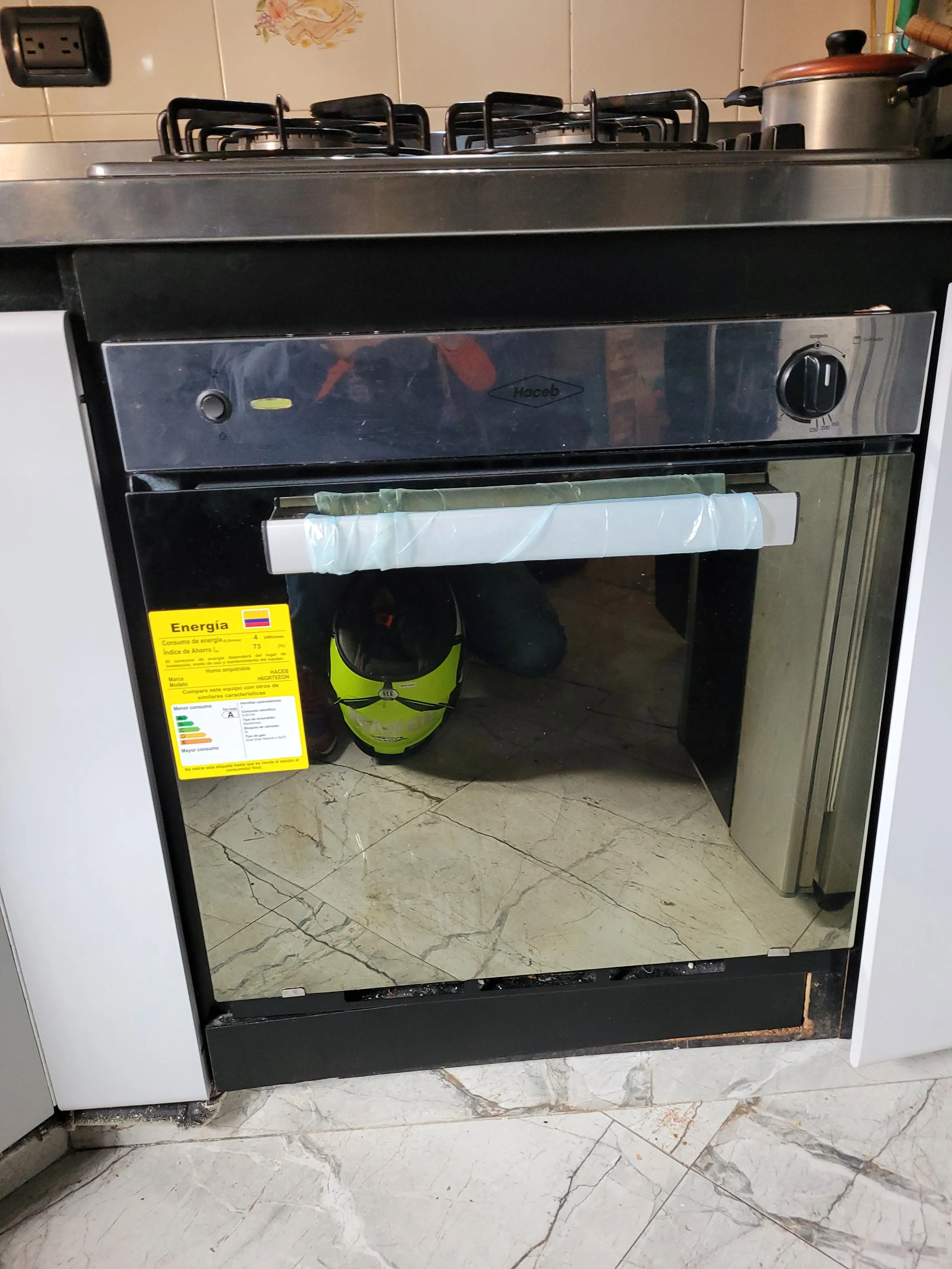 Estufa con un gorro de motocicleta y una etiqueta de energía en el electrodoméstico.