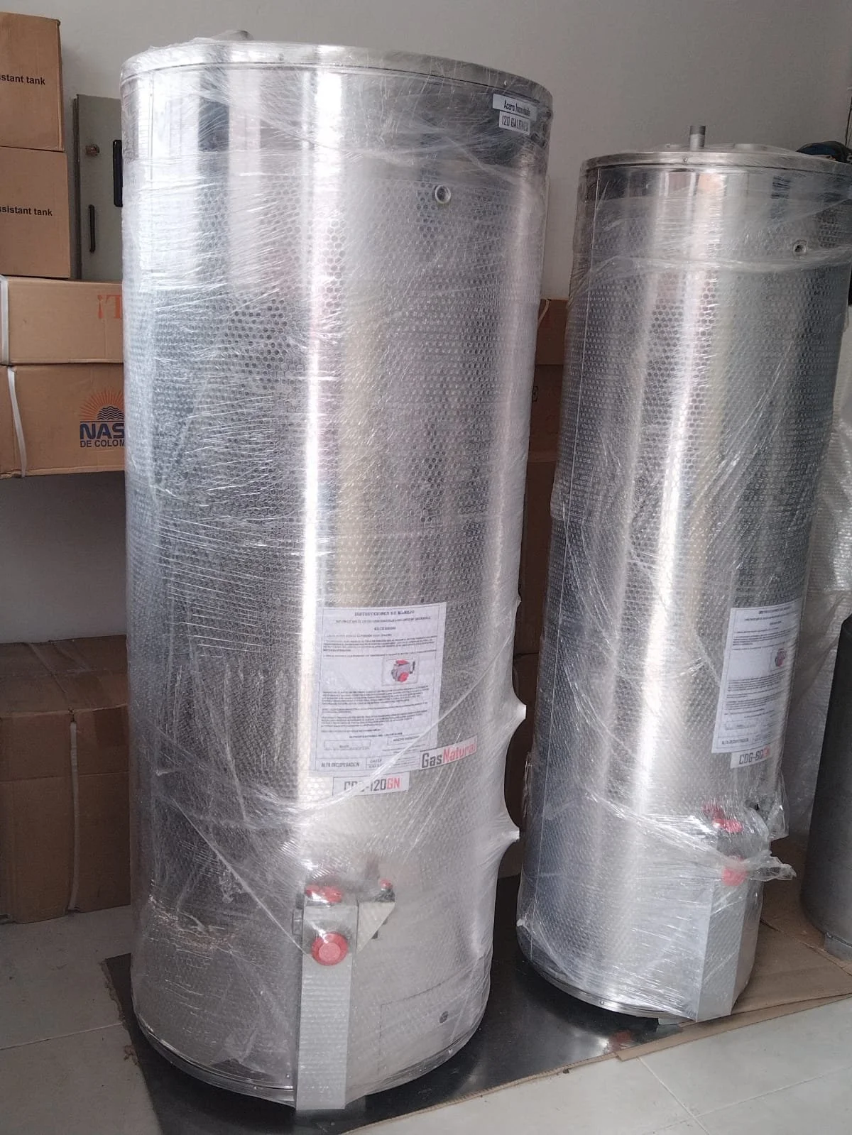 Dos tanques de gas natural envueltos en plástico en un espacio de almacenamiento.