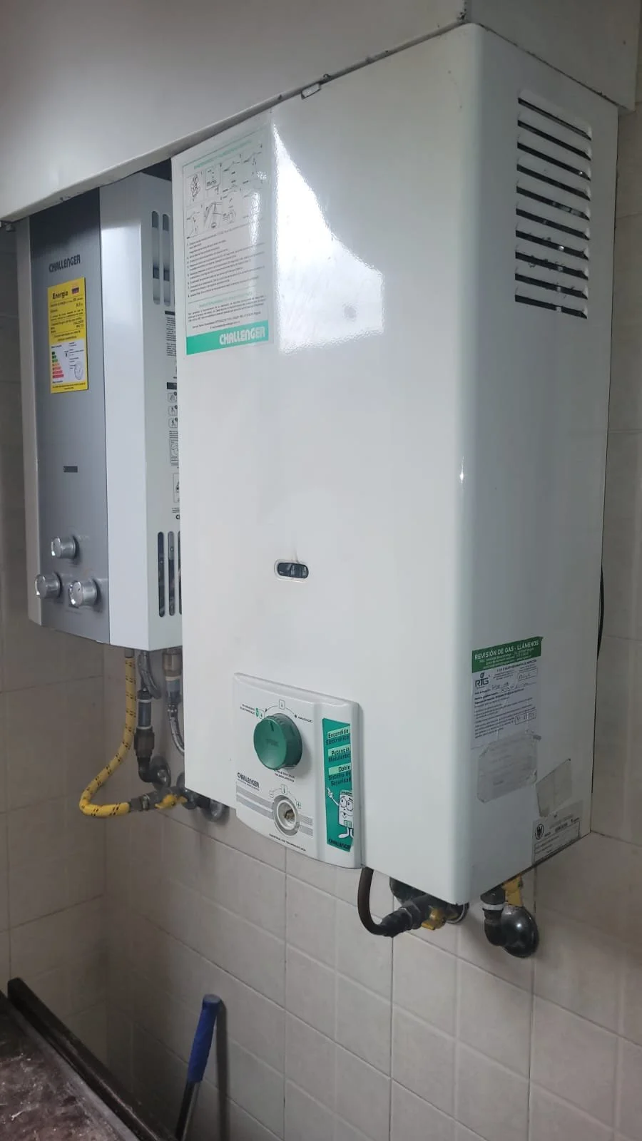 Calentador de agua de la marca Challenger instalado en la pared con controles y etiquetas en español.