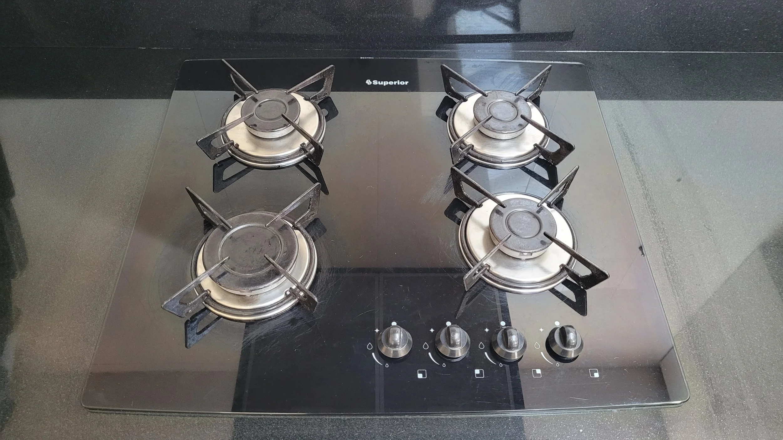 Estufa de cocina de cuatro quemadores de gas con controles de knob.