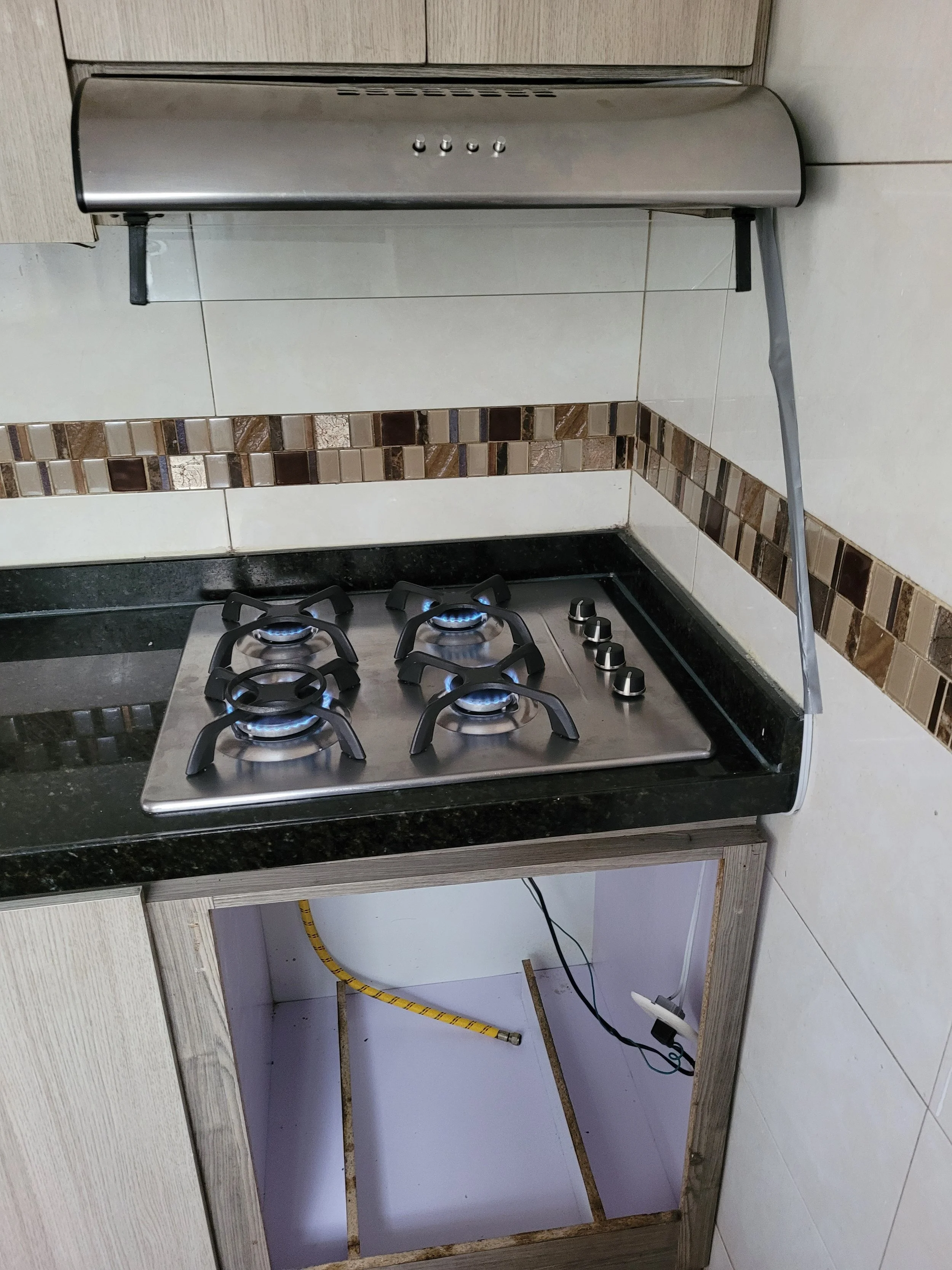 Estufa de gas en una cocina con espacio vacío debajo, sin gabinete o electrodomésticos en ese espacio