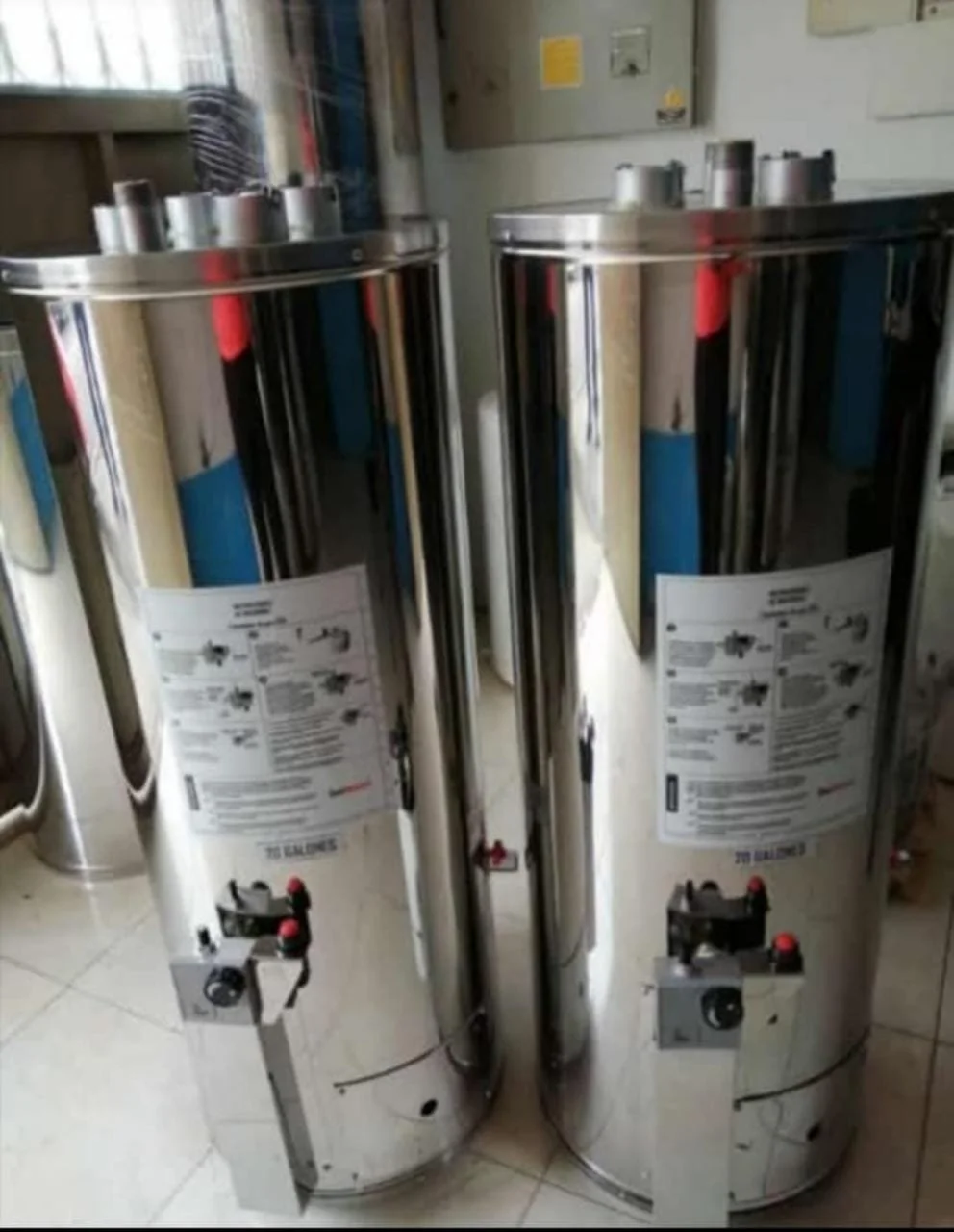 Dos calentadores de agua de tamaño grande y de color plateado en un espacio interior.