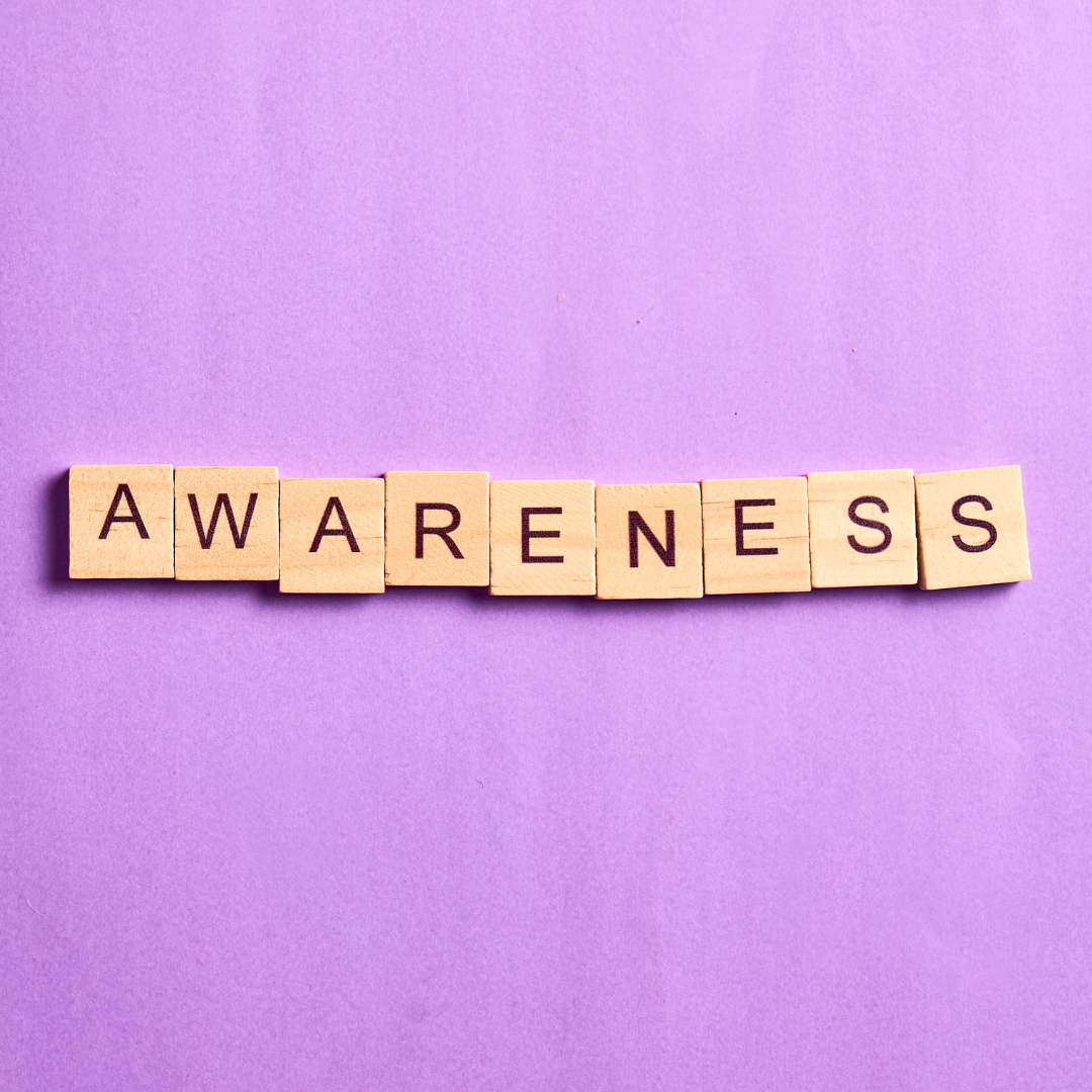 Scrabble tiles spelling 'AWARENESS' on a purple background.