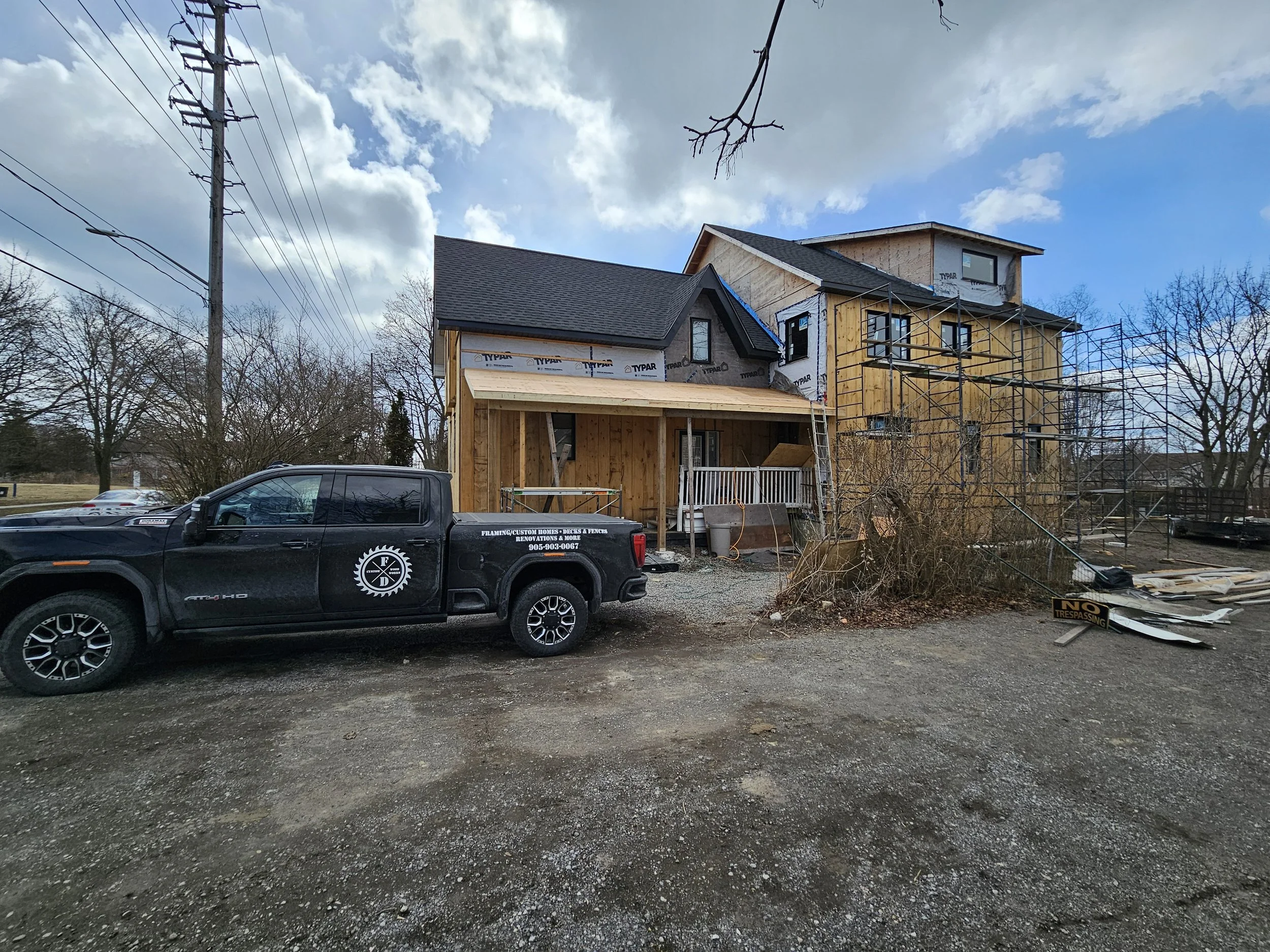 Under construction house with scaffolding, a pickup truck parked in front, and a 