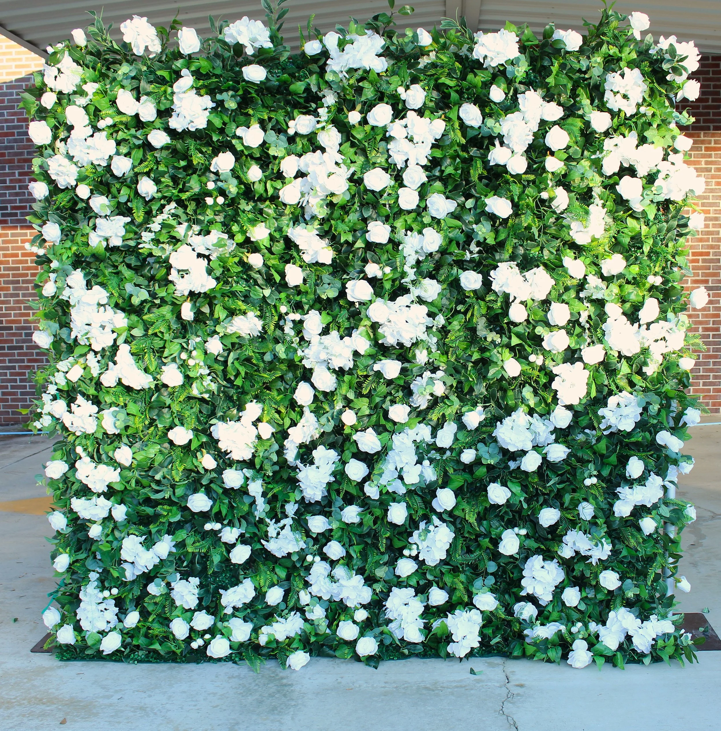 A large rectangular floral wall covered with white flowers and green foliage.