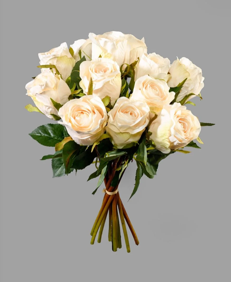 A bouquet of white roses with green leaves against a gray background.