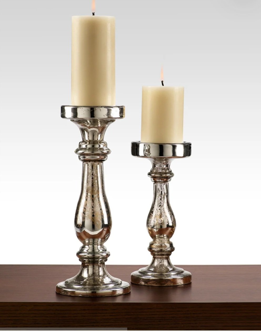 Two silver candlesticks with large cream-colored candles.