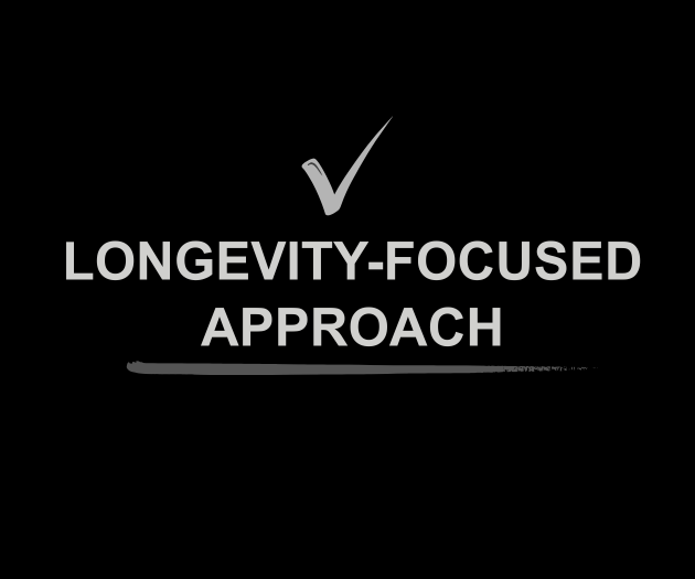 A black background with a gray checkmark above the text 'LONgevity-FOCUSED approach' in gray and white font, with a gray underline beneath the text.