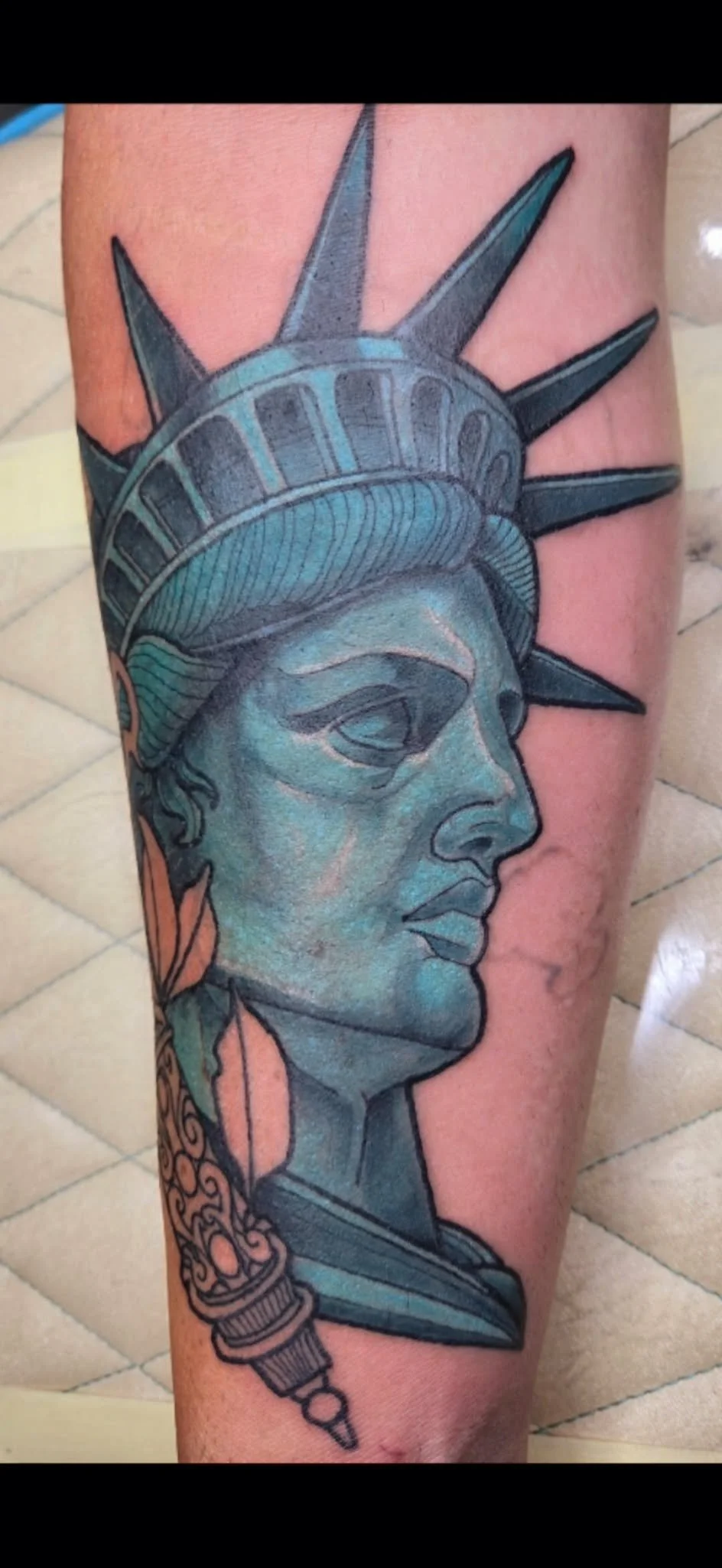 Tattoo of the Statue of Liberty with detailed shading and line work.