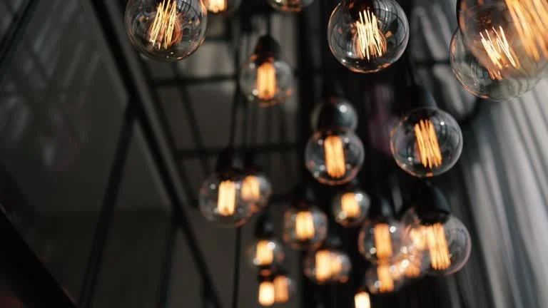 Multiple exposed filament light bulbs hanging from the ceiling in a modern interior.