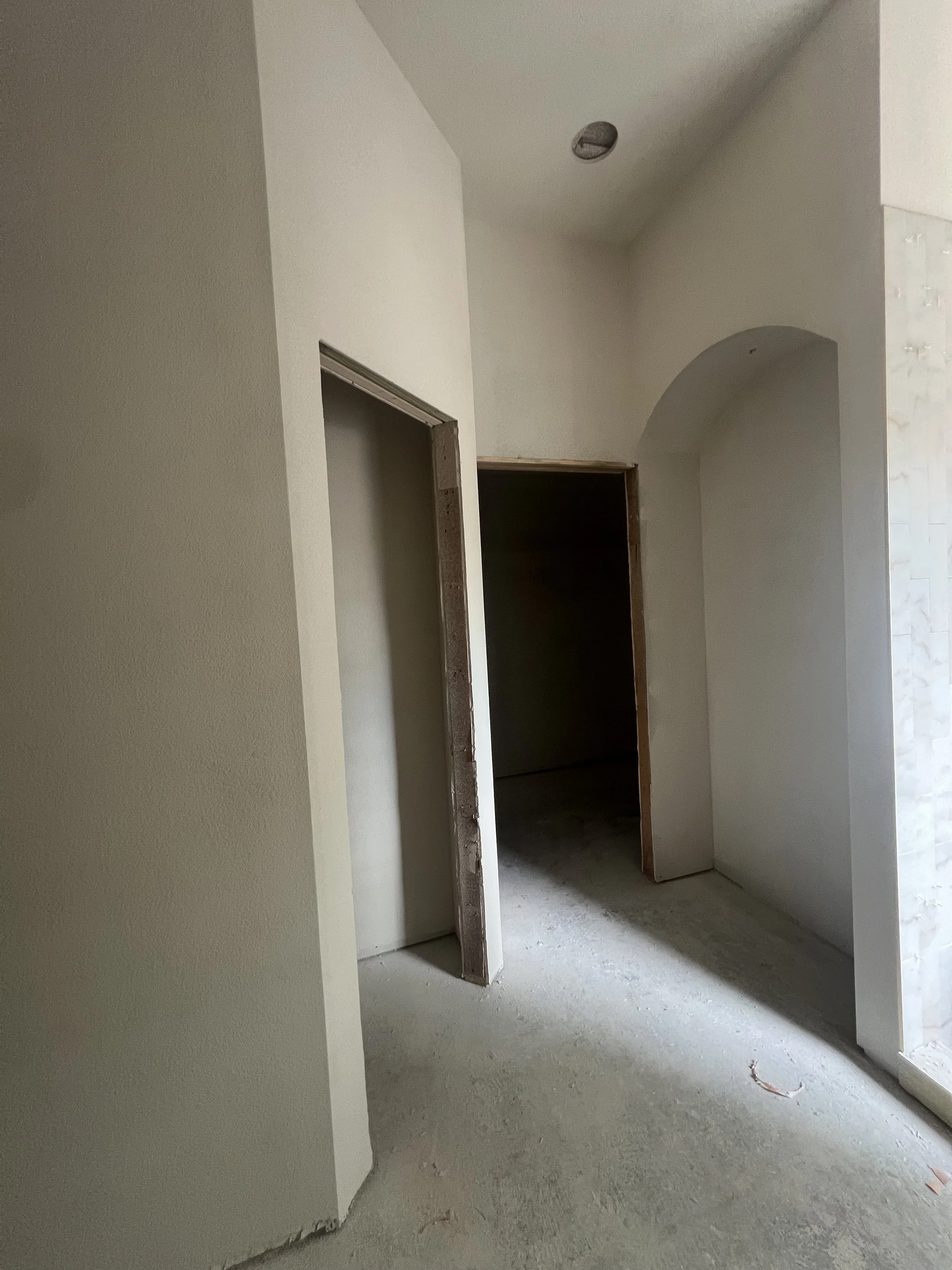 Interior of a house under construction with unfinished walls and open doorways.