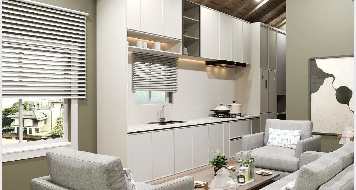 Modern living room with a kitchen in the background, featuring white cabinets, a window with blinds, and a small table with drinks and snacks.