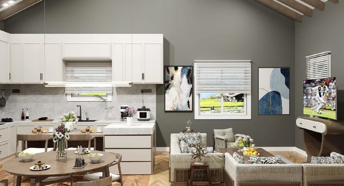 Open-concept living room and kitchen with gray walls, white cabinets, a round dining table with chairs, sofa and armchair with patterned pillows, windows with blinds, wall art, and a flat-screen TV.