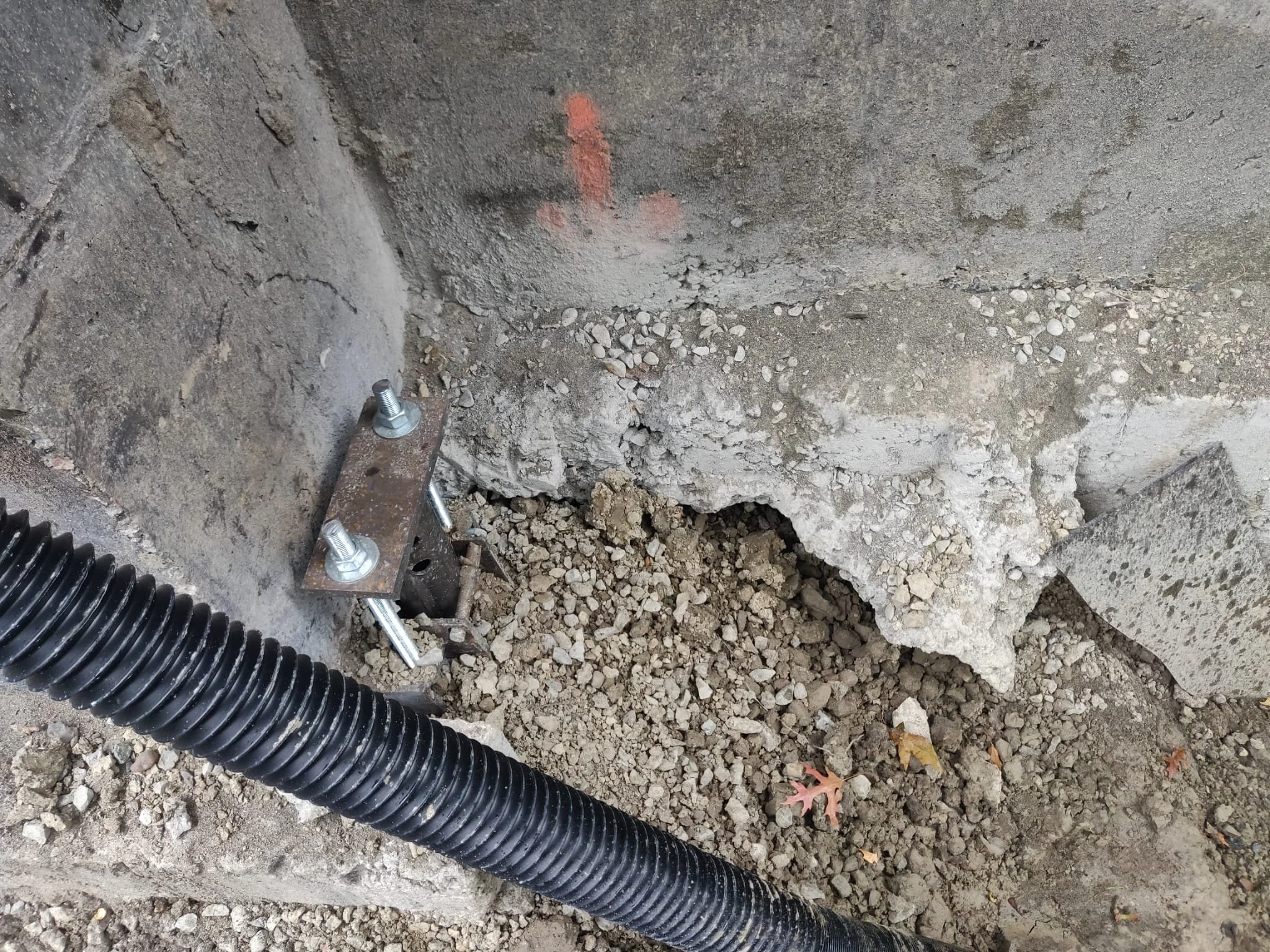 A helical pile installed flush against the foundation stem wall