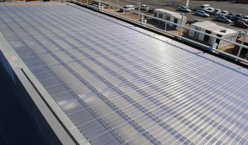 A large array of solar panels installed on a rooftop in an urban area.