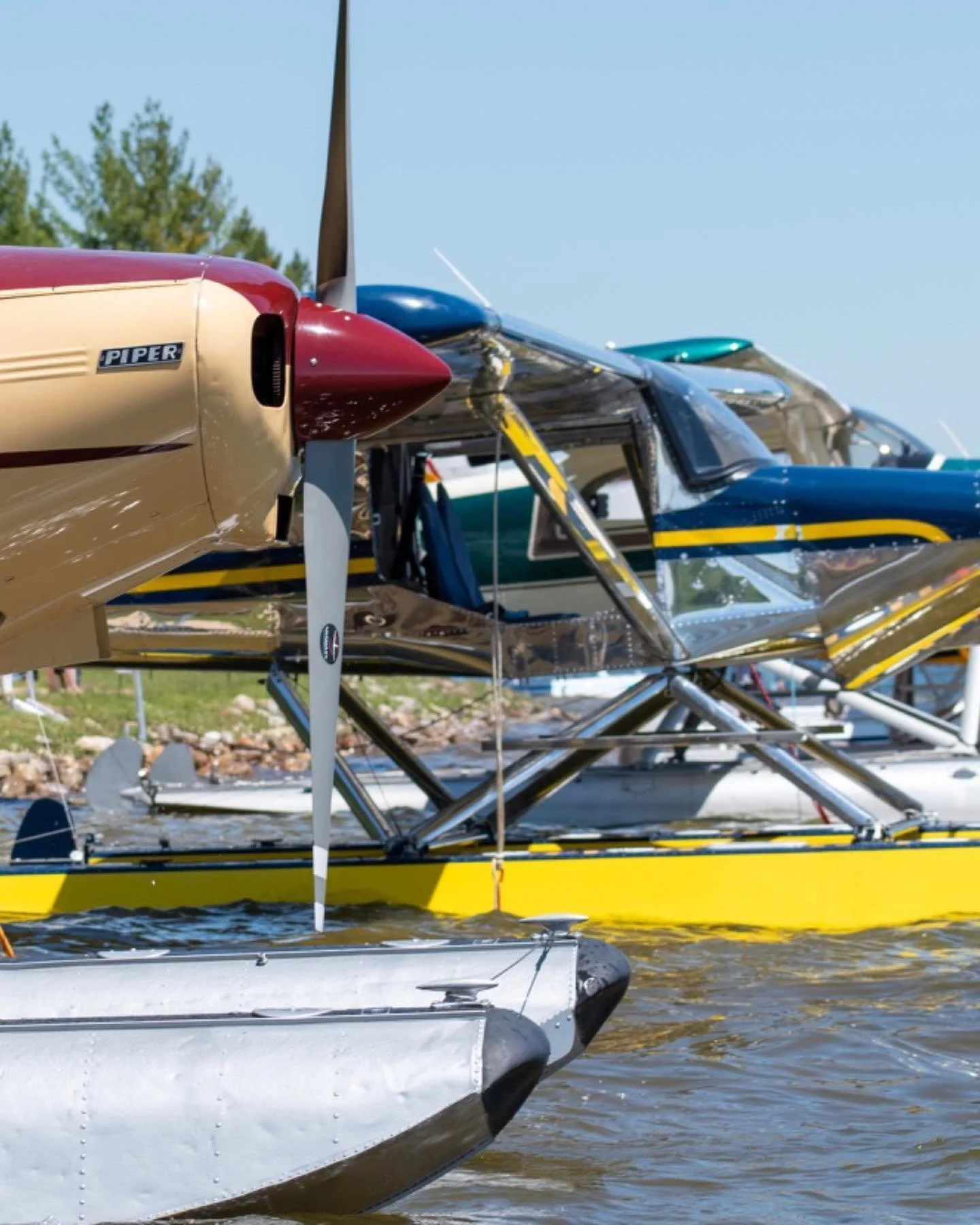 Piper and Murphy Rebel seaplanes on floats moored together on a Michigan lake