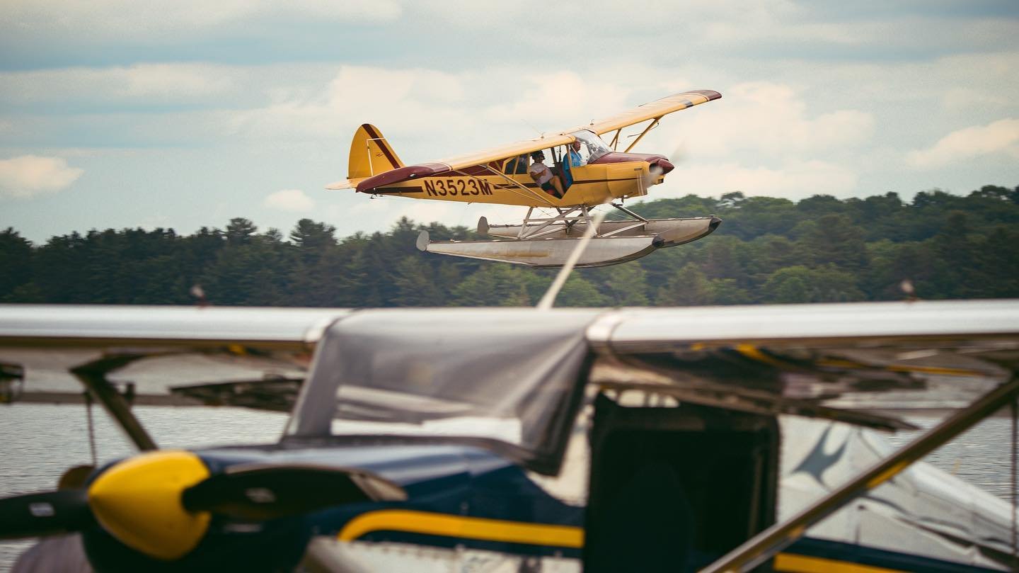 Seaplane taking off from a Michigan lake with another floatplane in the foreground