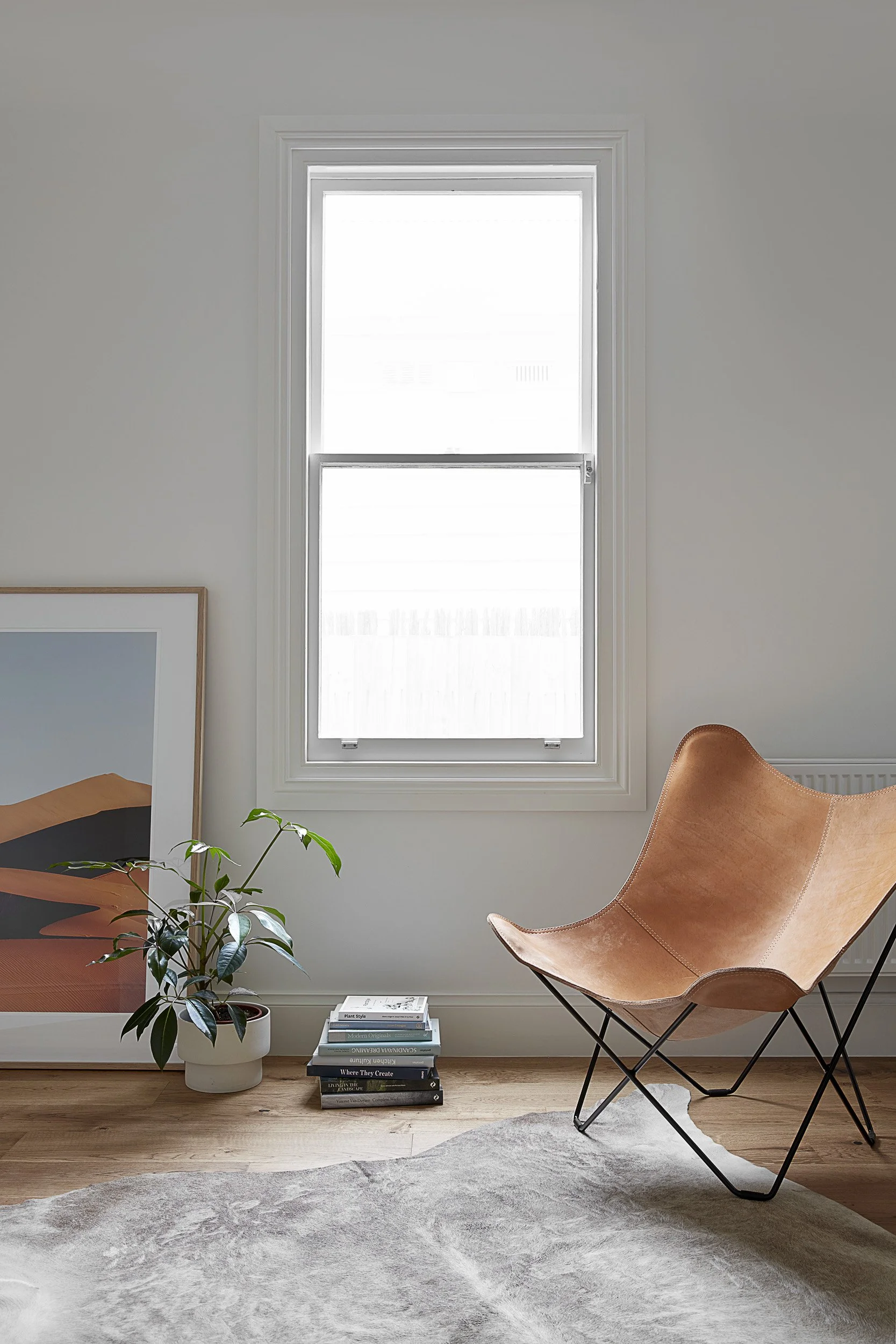 Window Frame with timber floors and leather chair