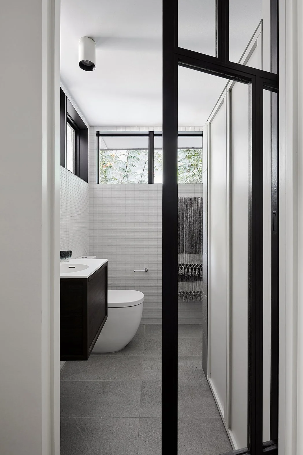 White tiled bathroom with sliding door