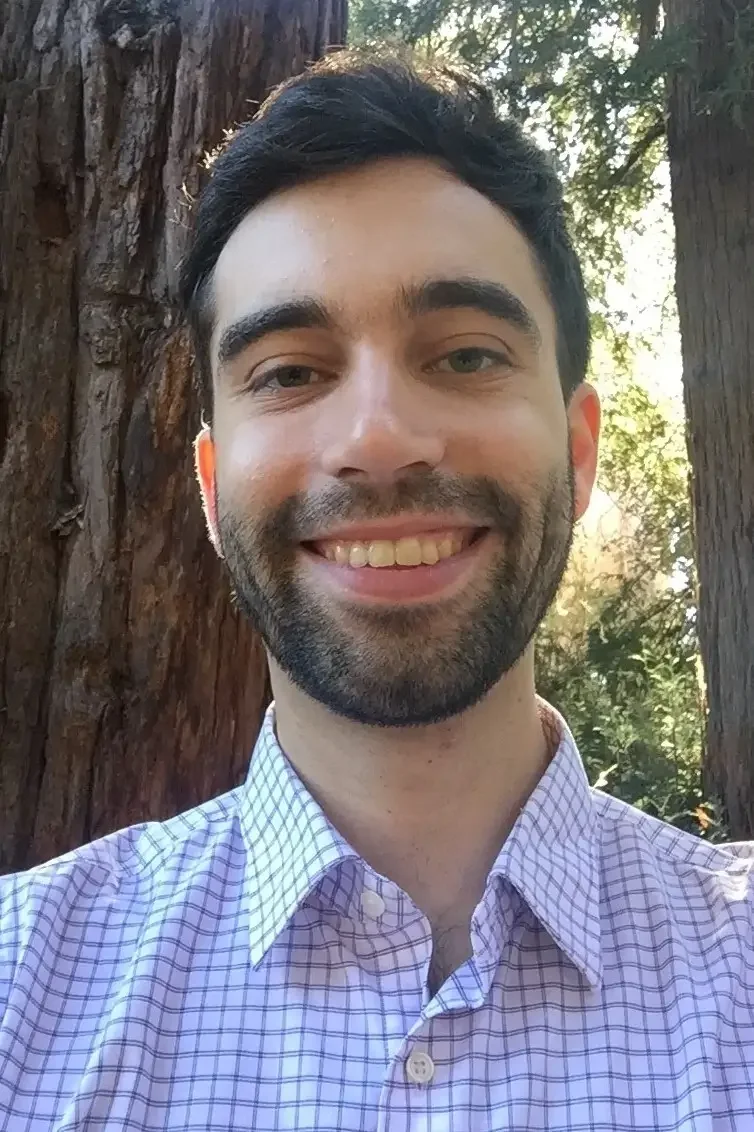 Profile picture of Matthew Condakes, a smiling man with dark hair and a beard pictured outdoors with trees in the background.