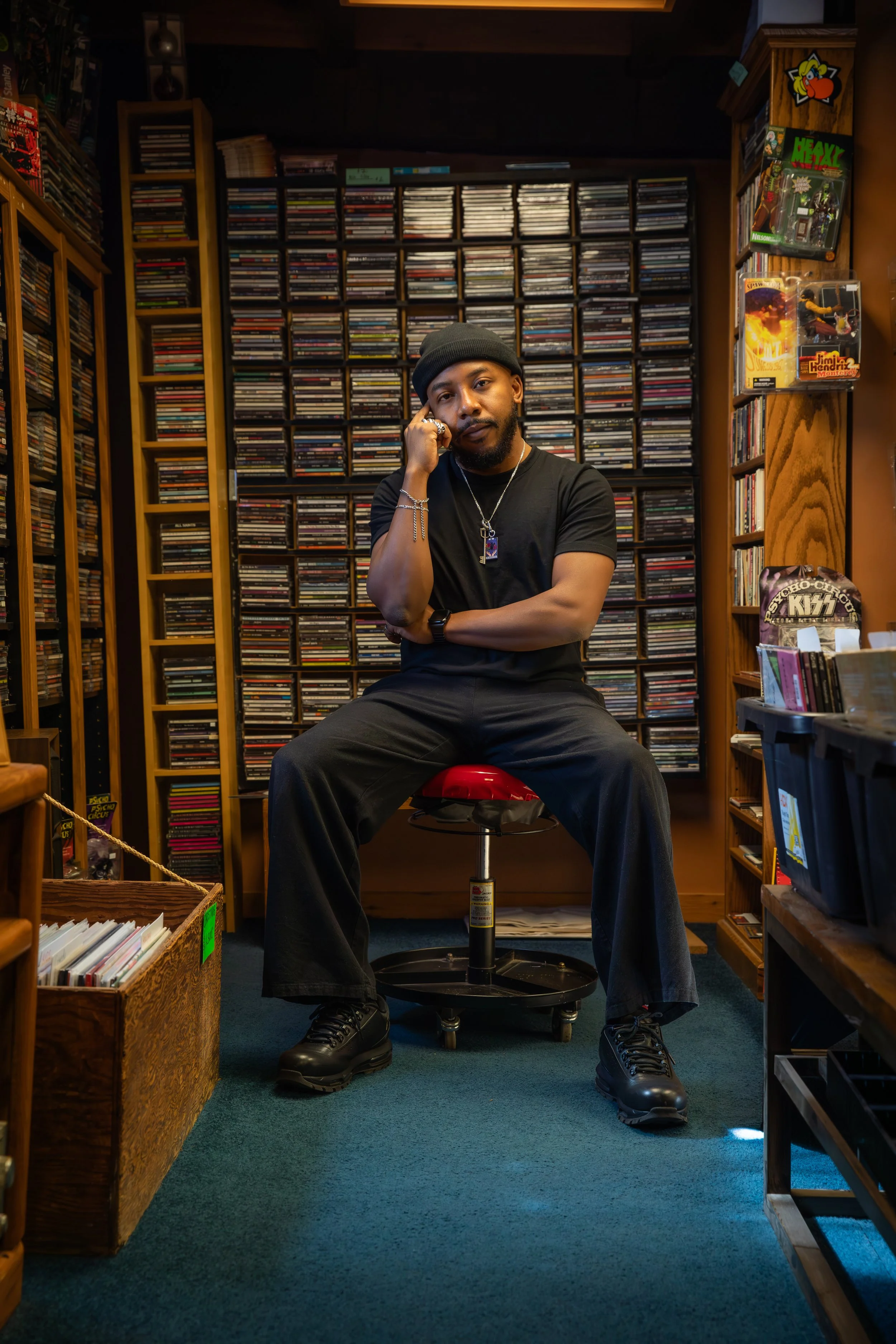 Cory standing by an open car trunk at night wearing a black beanie and jacket