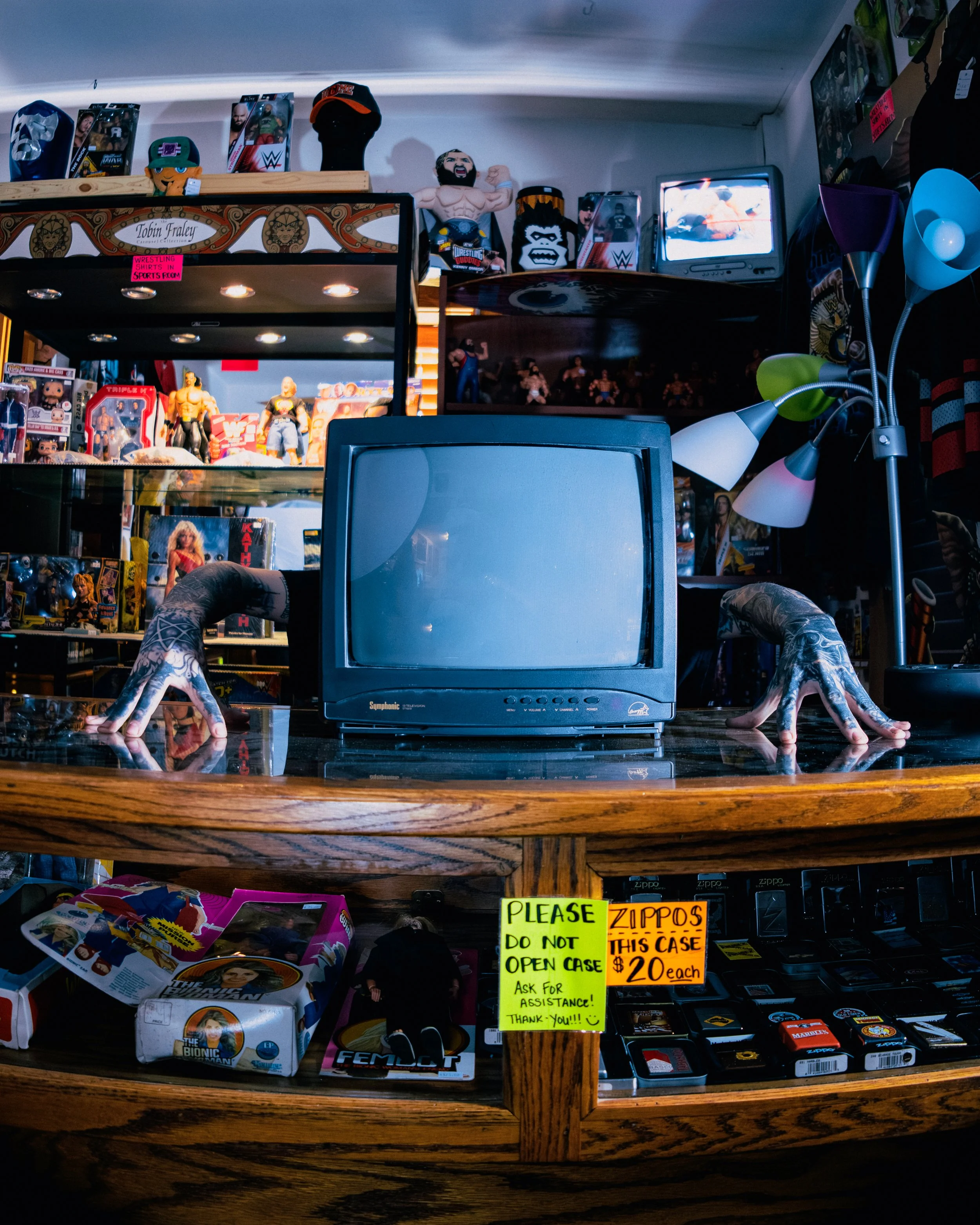 Close-up of a smiling woman with curly hair, wearing glasses, hoop earrings, and a striped shirt, indoors.