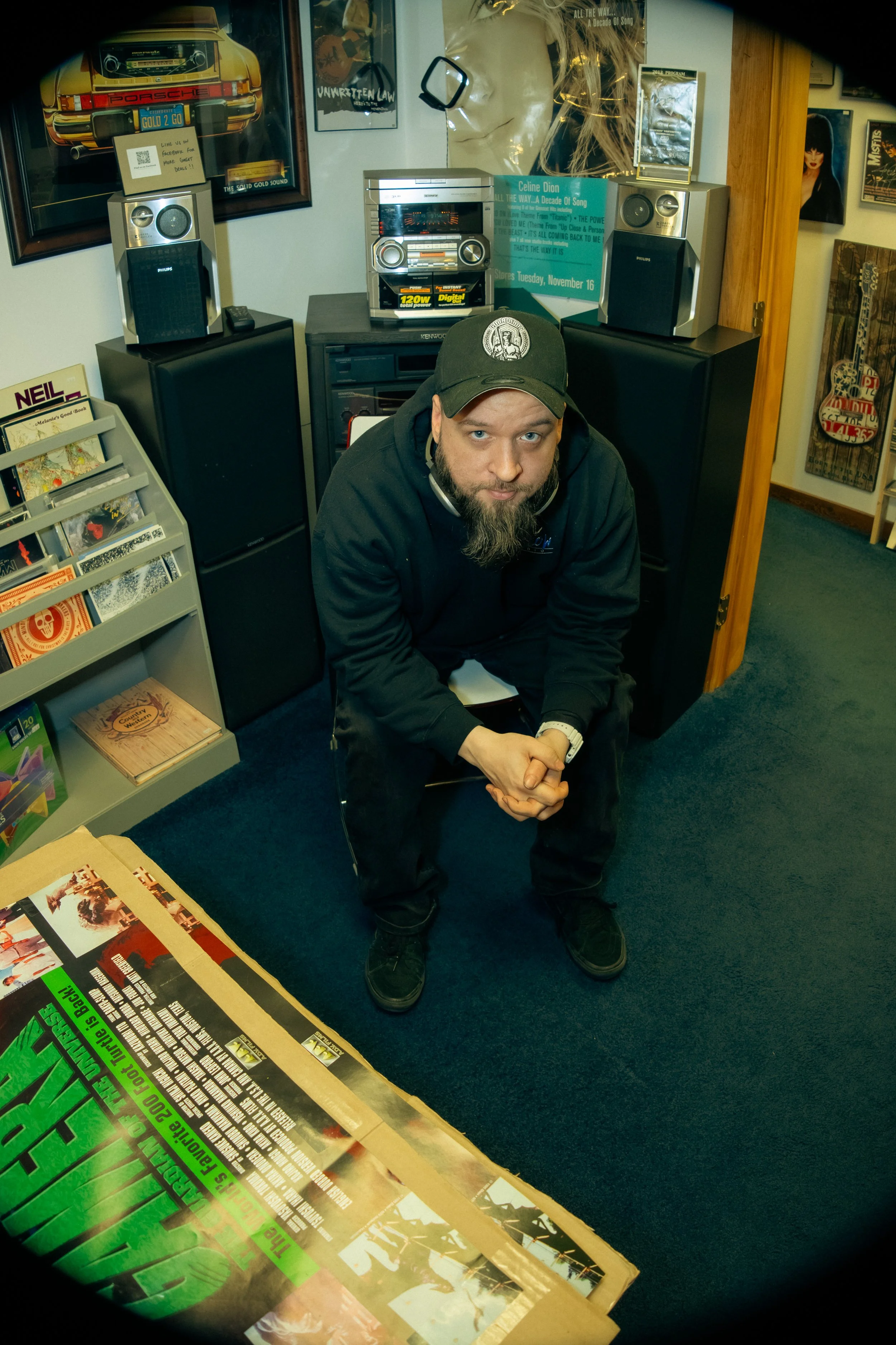 A rugged mountainous landscape with patches of snow and ice, steaming hot springs or fumaroles, reddish-brown rocky terrain, and a cloudy sky.