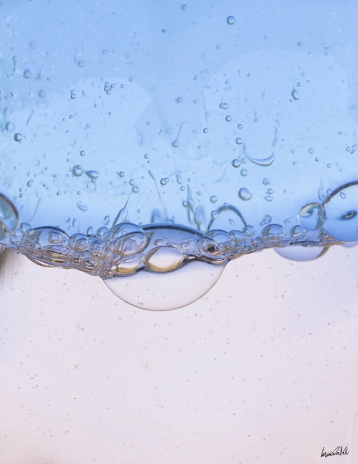 Aguas con burbujas en movimiento, con un fondo azul y rosa