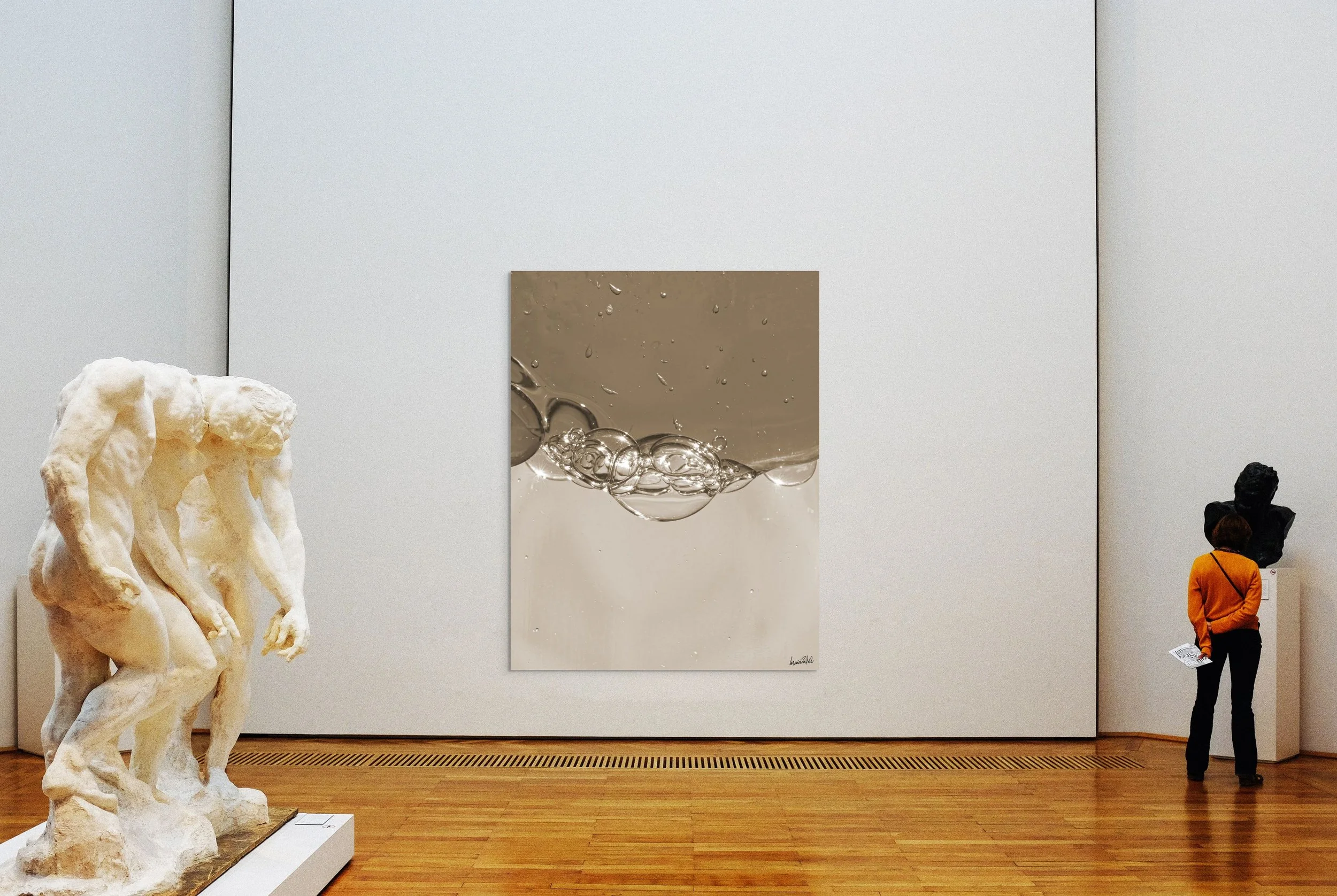 Museo de arte con esculturas de mármol y una pintura moderna en la pared, una visitante observa la obra a la derecha.