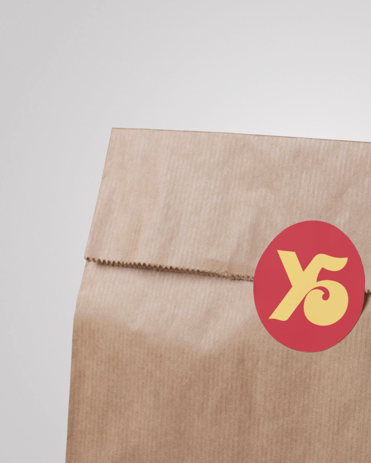 Brown paper bag with a yellow and red X5 sticker on it.