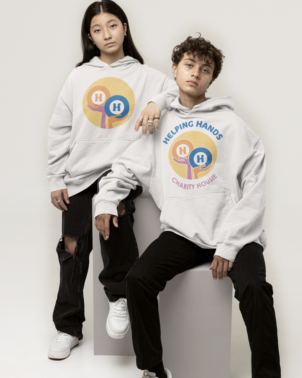 Two young people wearing light gray hoodies with a charity logo, one seated and the other standing, set against a plain background.