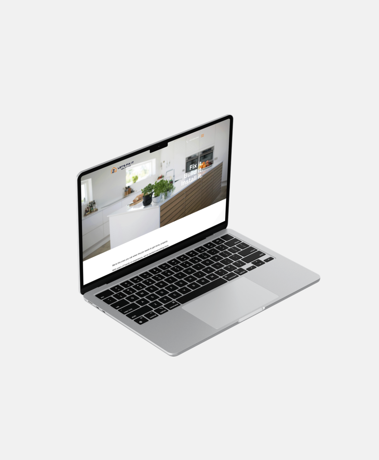 Silver laptop with black keyboard displaying a kitchen renovation website on a plain white background.