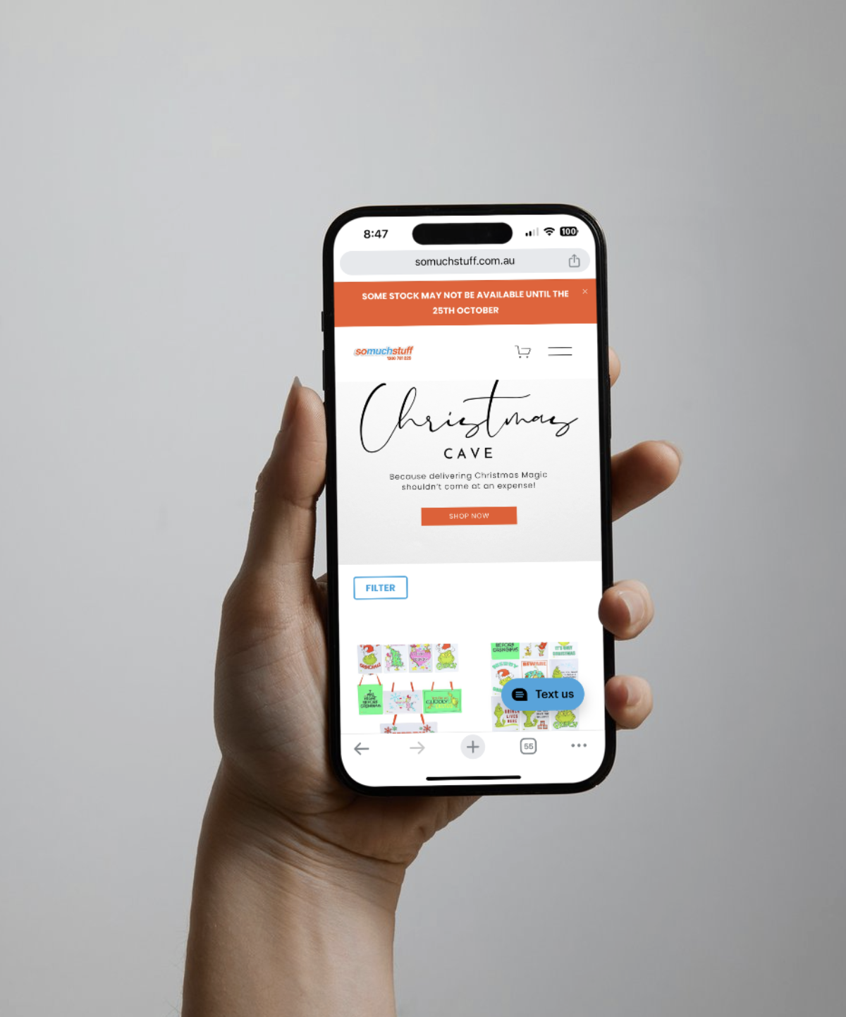A hand holding a smartphone displaying an online Christmas shopping website with festive holiday-themed products.