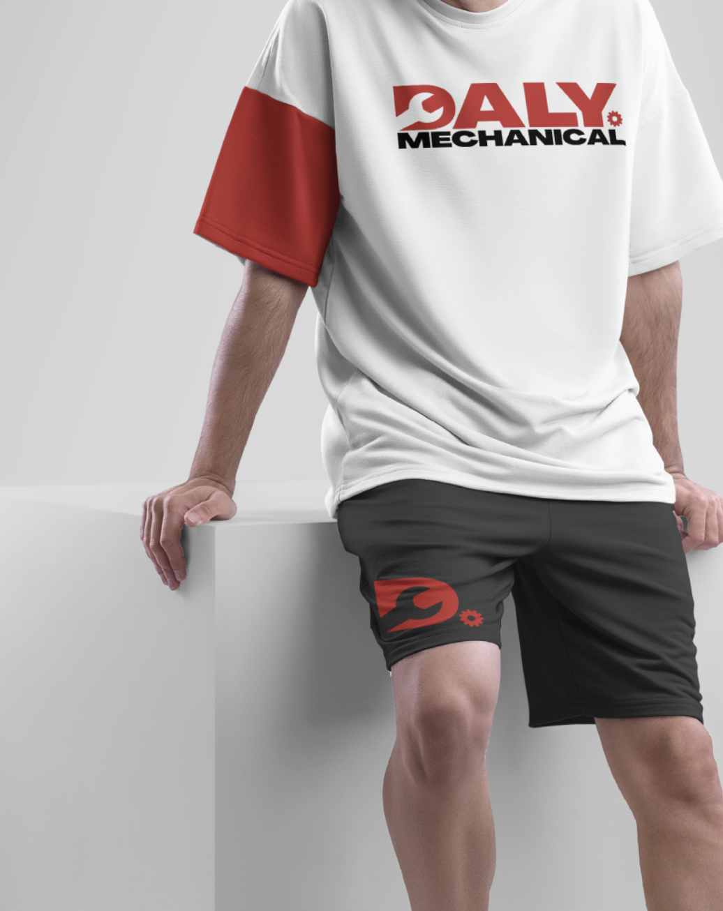 Person wearing a white and red mechanic-themed t-shirt and black shorts with mechanic logo, standing against a white background.
