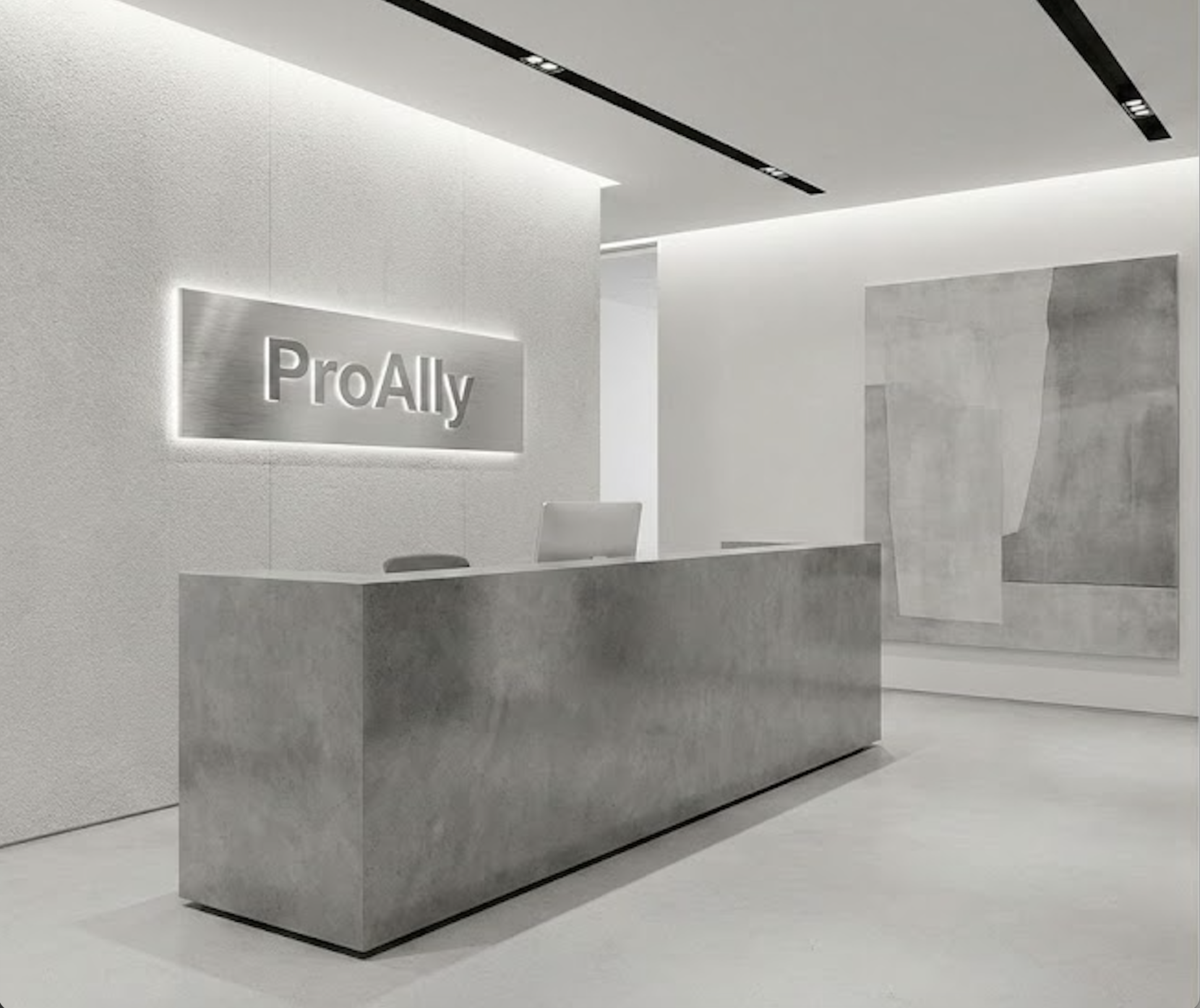 Modern minimalist reception area with a concrete desk, a computer, wall art, and a illuminated "ProAlly" sign.