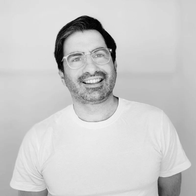 Photograph of Andrew Kolotelo in a head shot format, showing head and shoulders only.