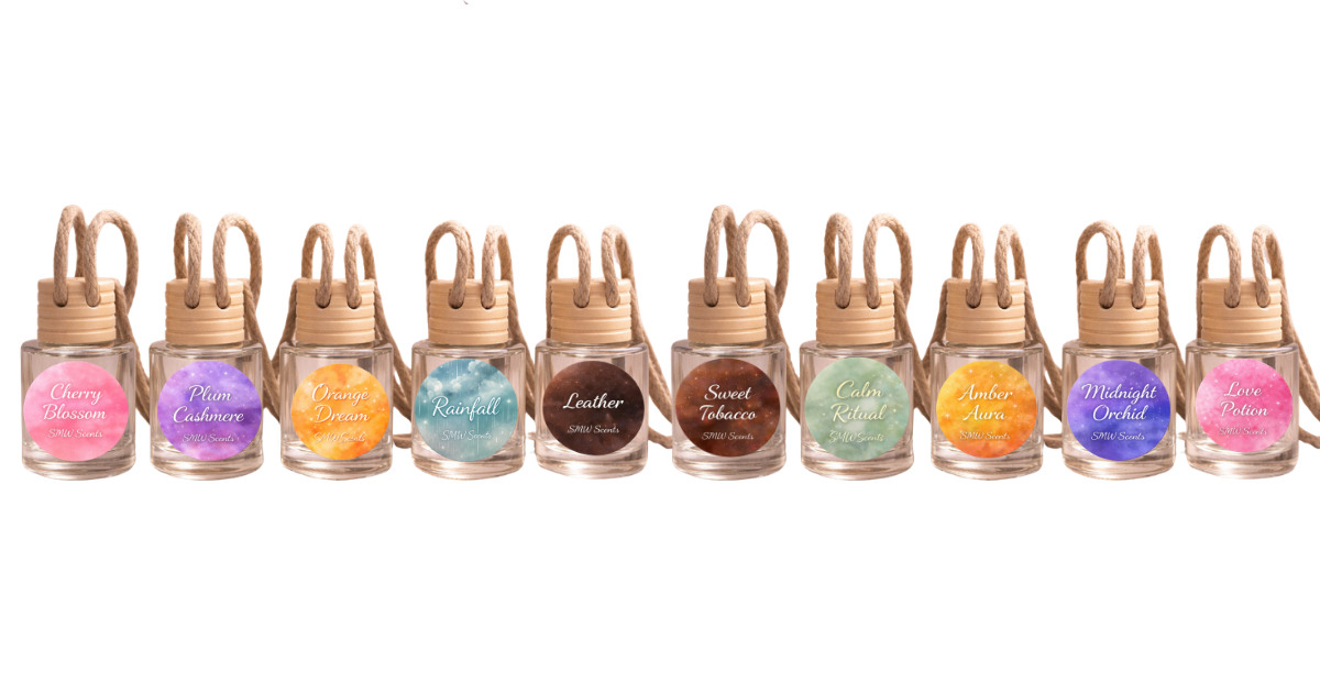Collection of ten small glass bottles labeled with different scents, from left to right: Cherry Blossom, Plum Cashmere, Orange Dream, Rainfall, Leather, Sweet Tobacco, Calm Ritual, Amber Aura, Midnight Orchid, Love Potion.