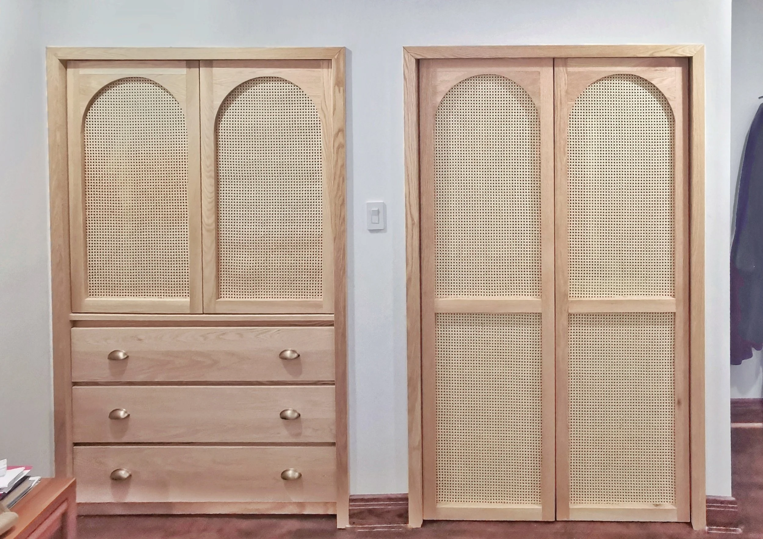 Two wooden cabinets with rattan or cane inserts, one with four drawers and the other with two doors, placed against a white wall.