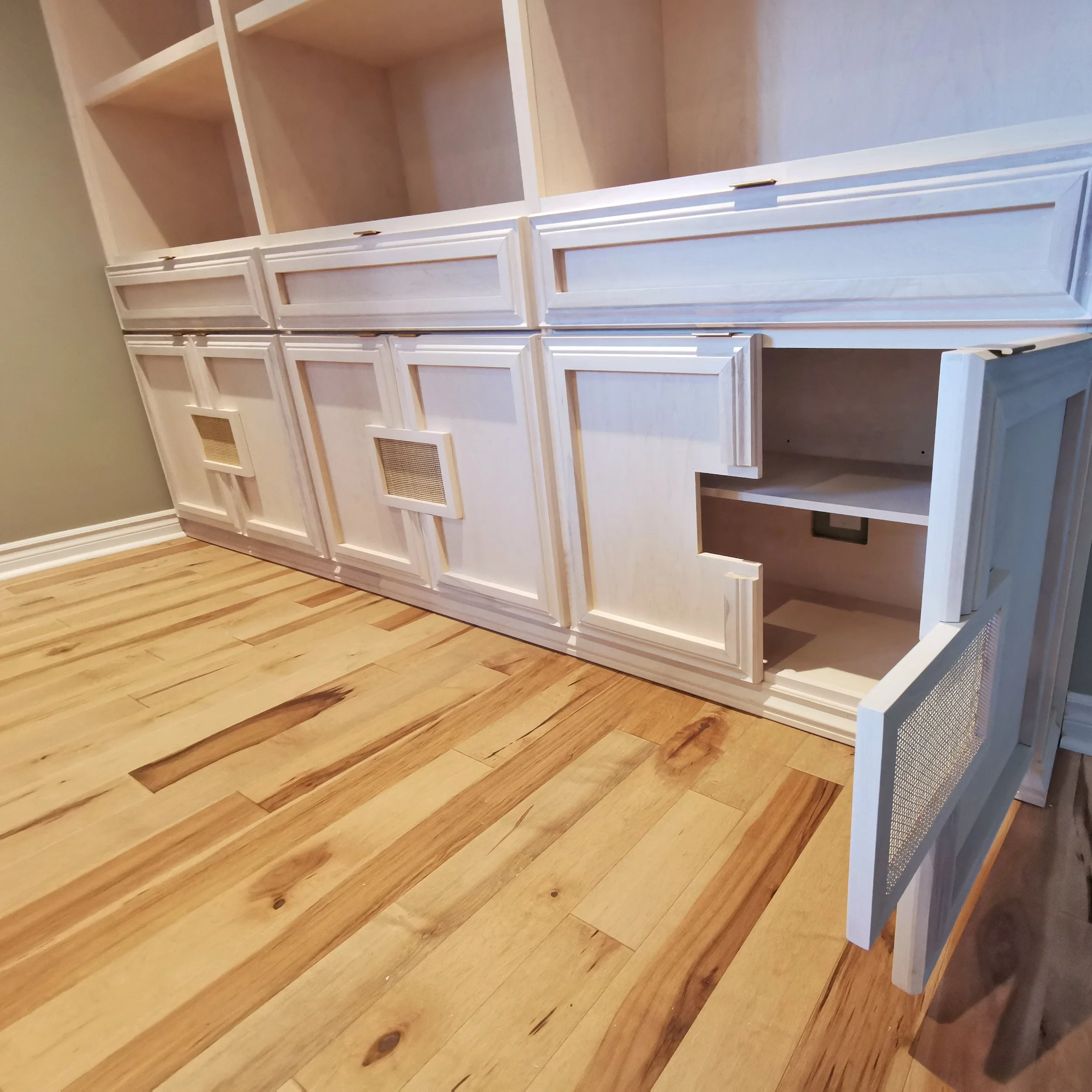 Unfinished white wooden cabinet with open doors, set against a beige wall and hardwood floor.