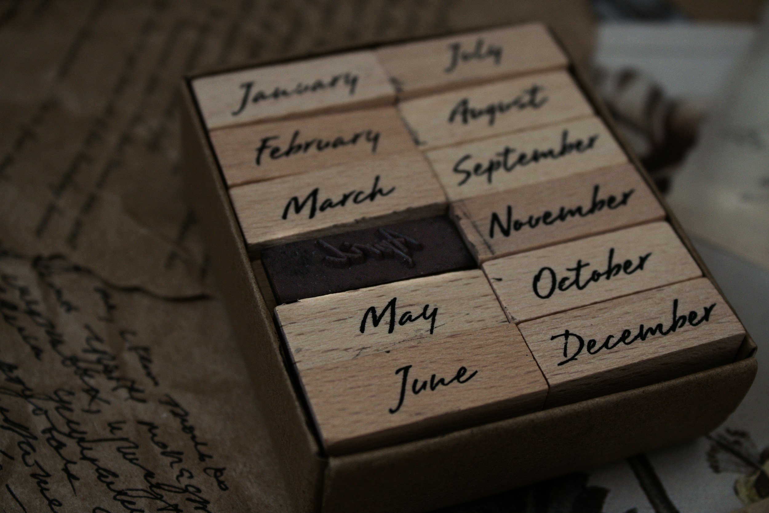 A wooden block calendar with the months written on individual wooden tiles, arranged in the order of the months.