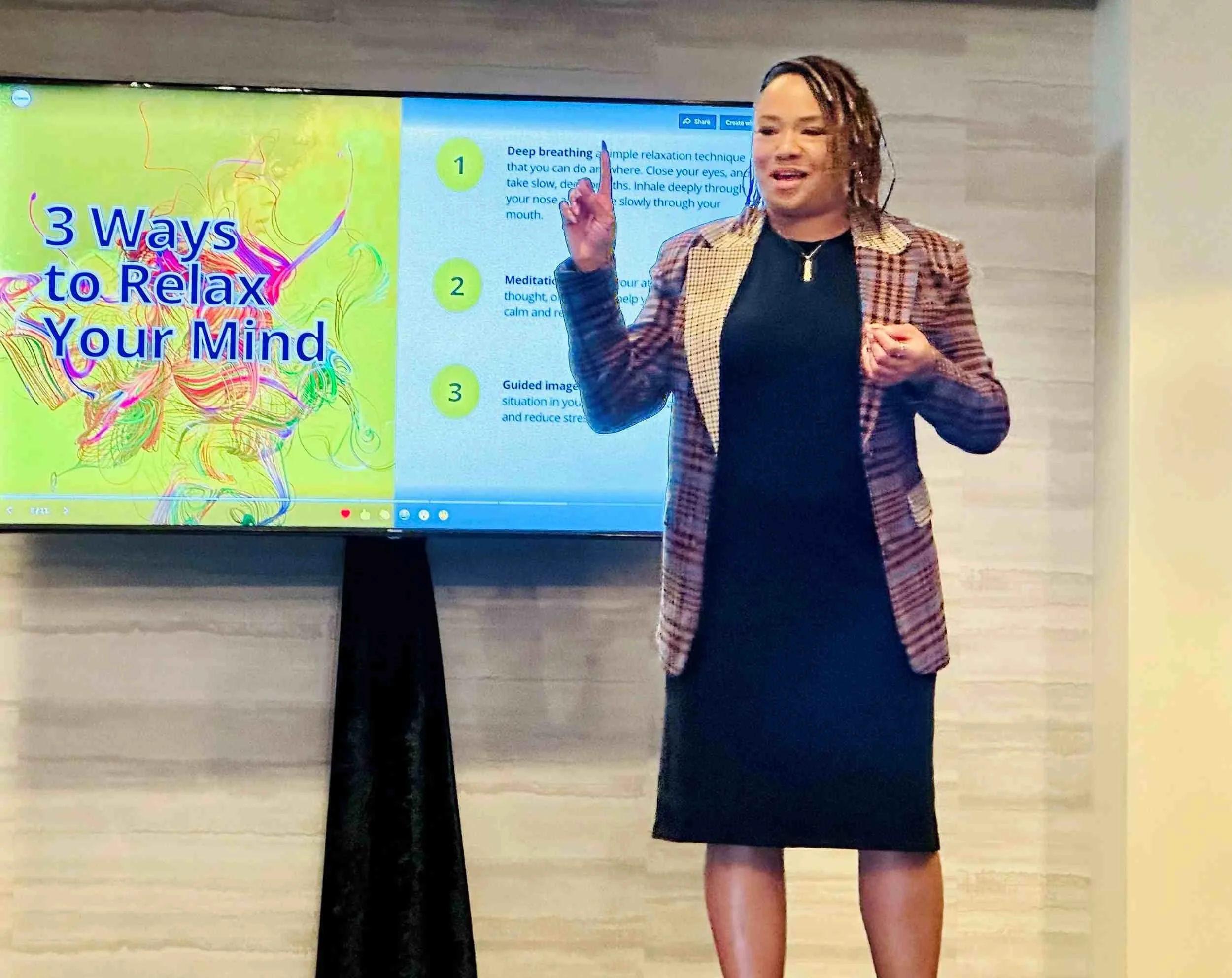 A woman standing in front of a large screen displaying a presentation titled '3 Ways to Relax Your Mind'. She is speaking and gesturing with her right hand. The screen shows a colorful graphic and three numbered points about relaxation techniques.