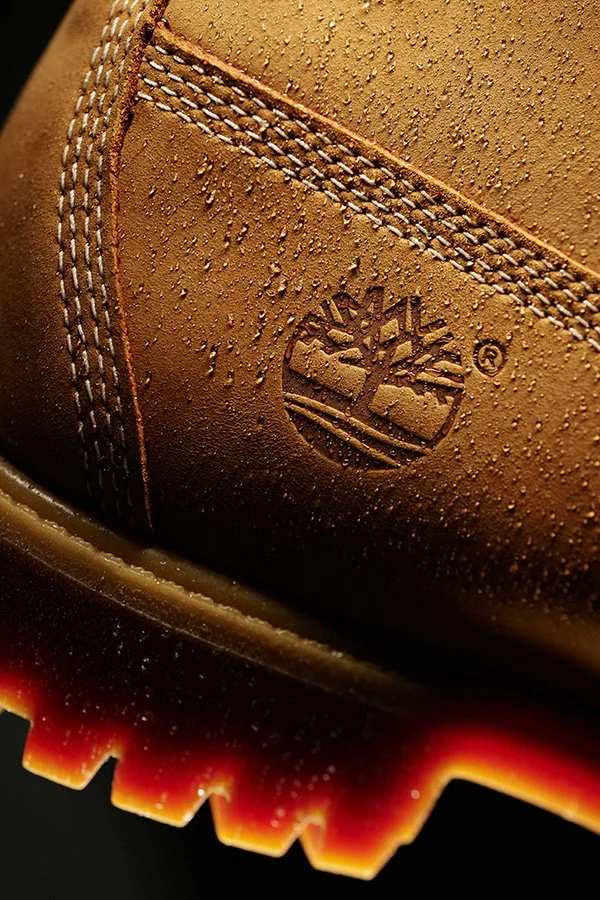 Close-up of a yellow Timberland boot with water droplets on the nubuck surface.