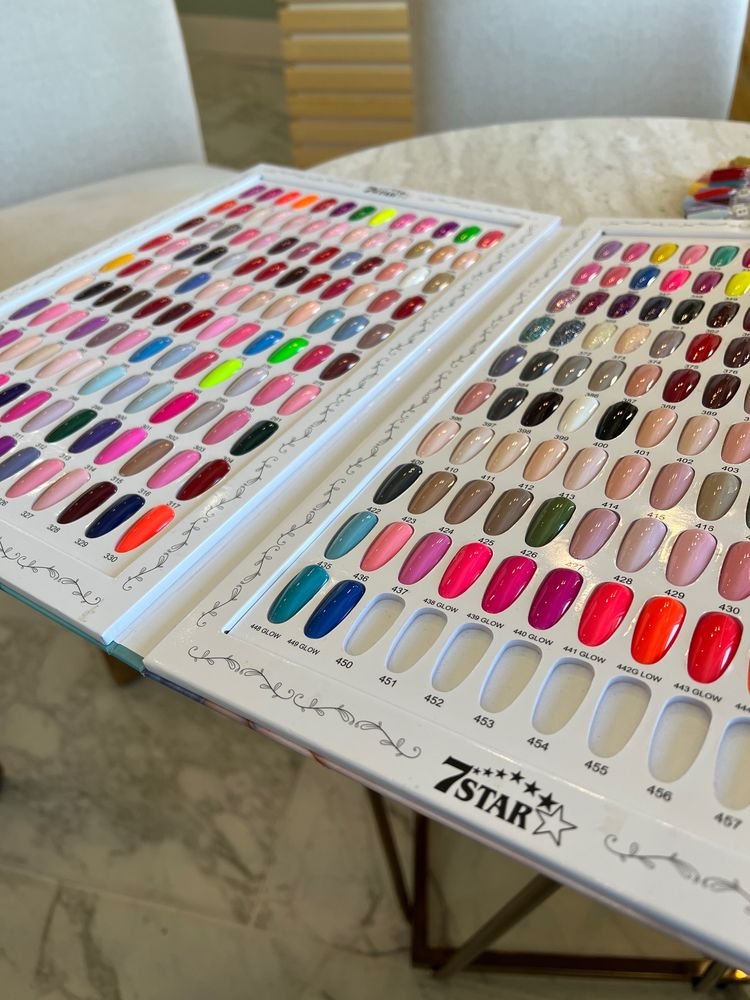 Nail polish color samples displayed on two boards with various shades of nail polish arranged in rows.