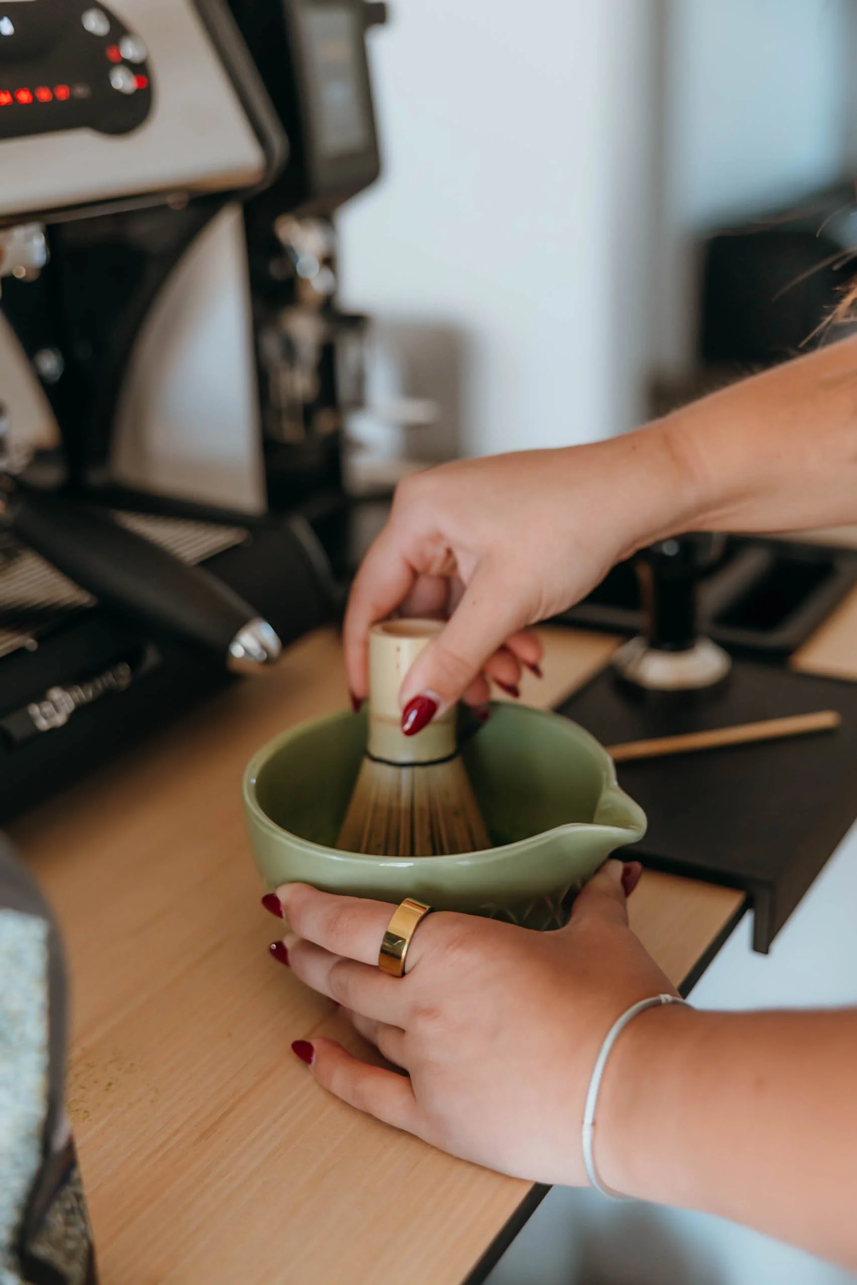 A professional barista whisking matcha before serving it to a customer.